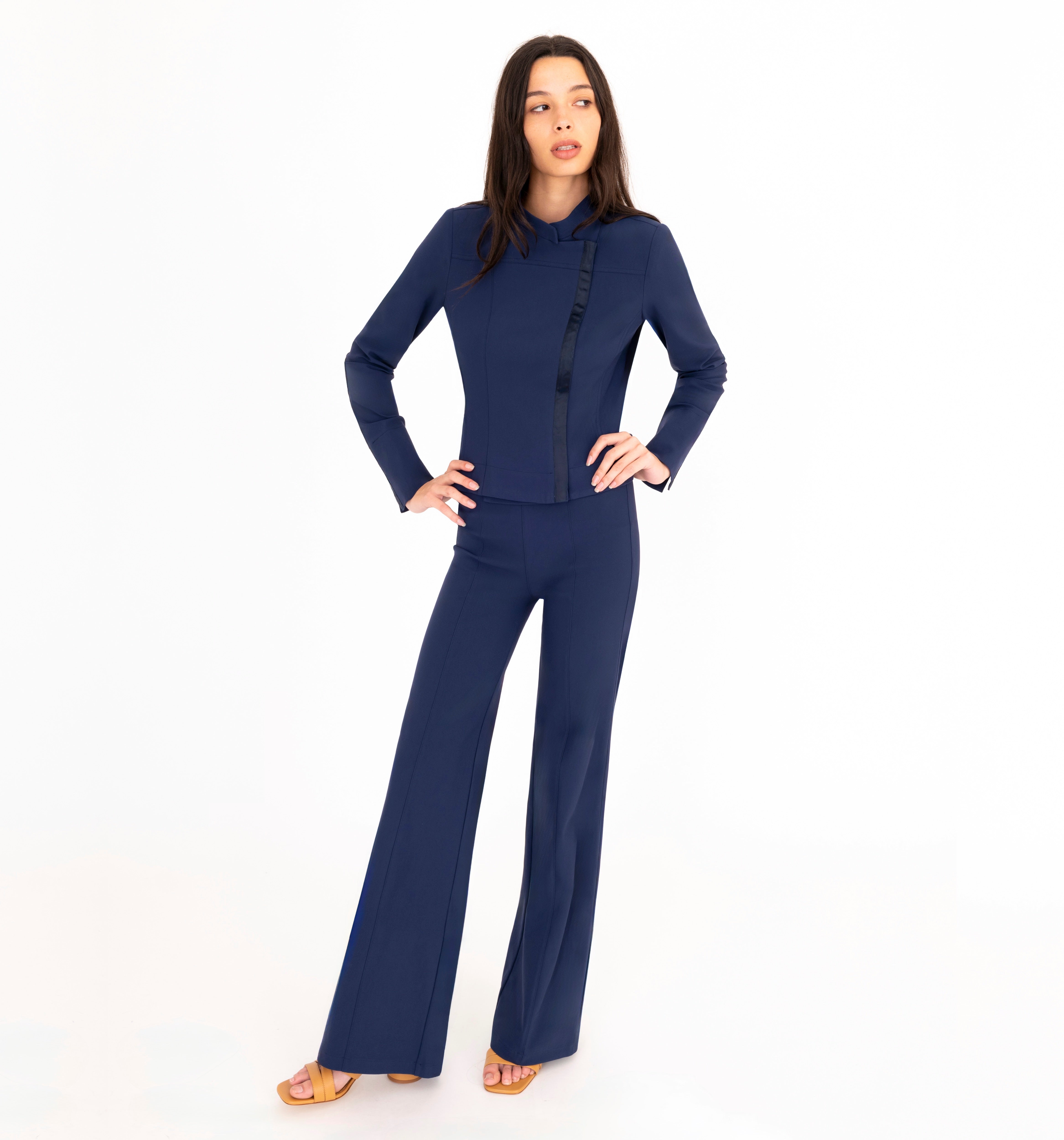 Woman wearing a navy blue jacket and pants on a white background