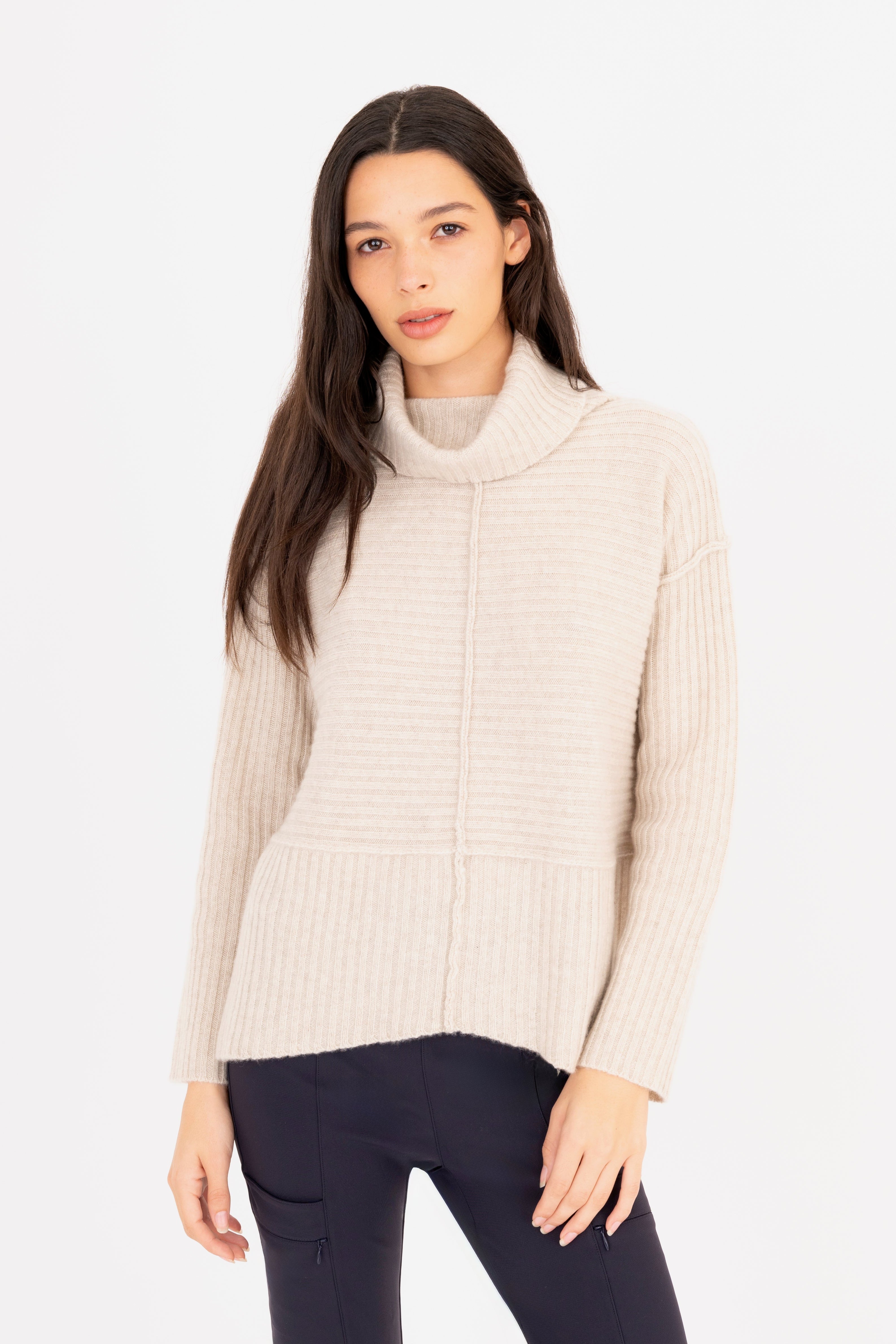 Woman wearing a beige ribbed sweater on a white background