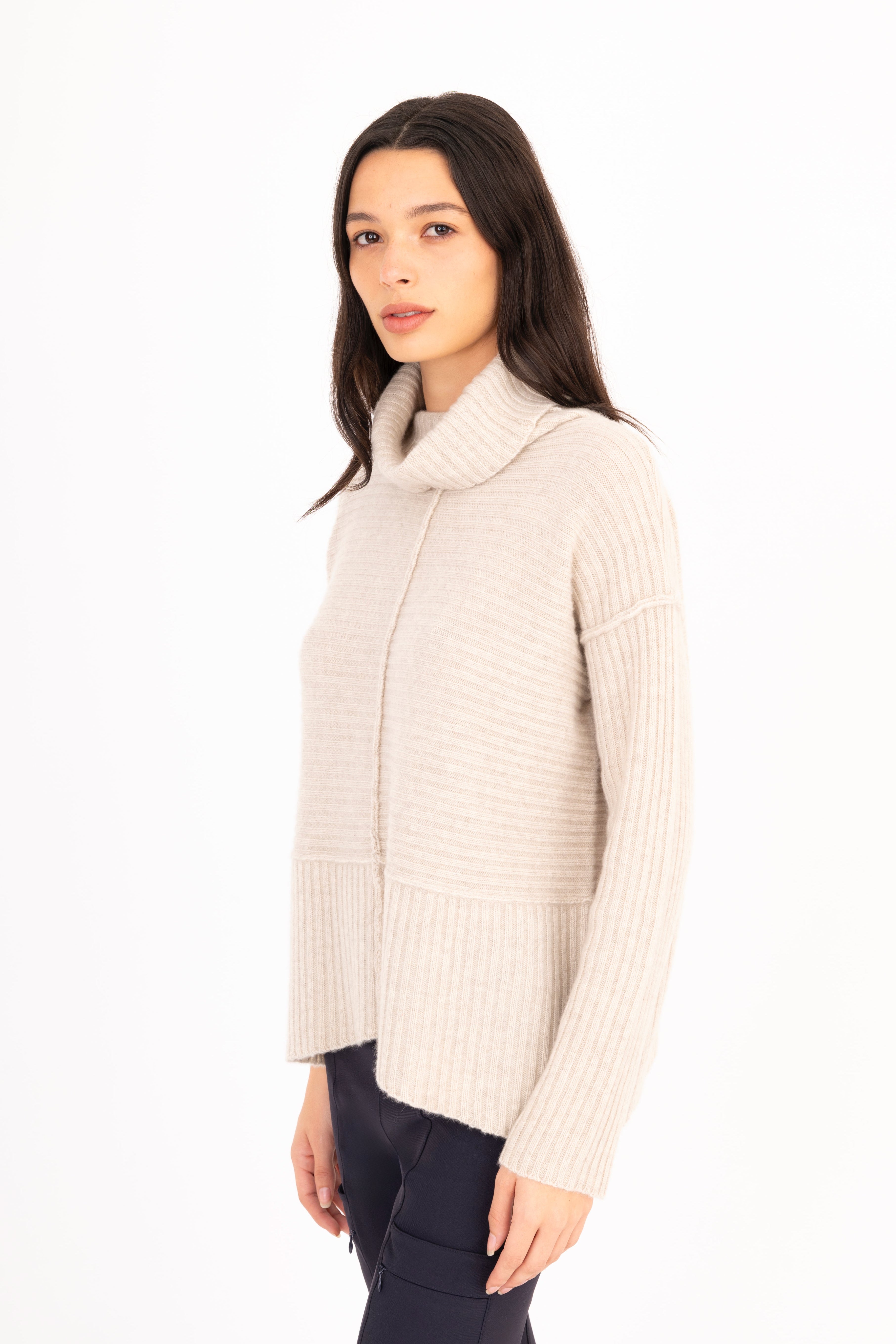 Woman wearing a beige ribbed sweater on a white background