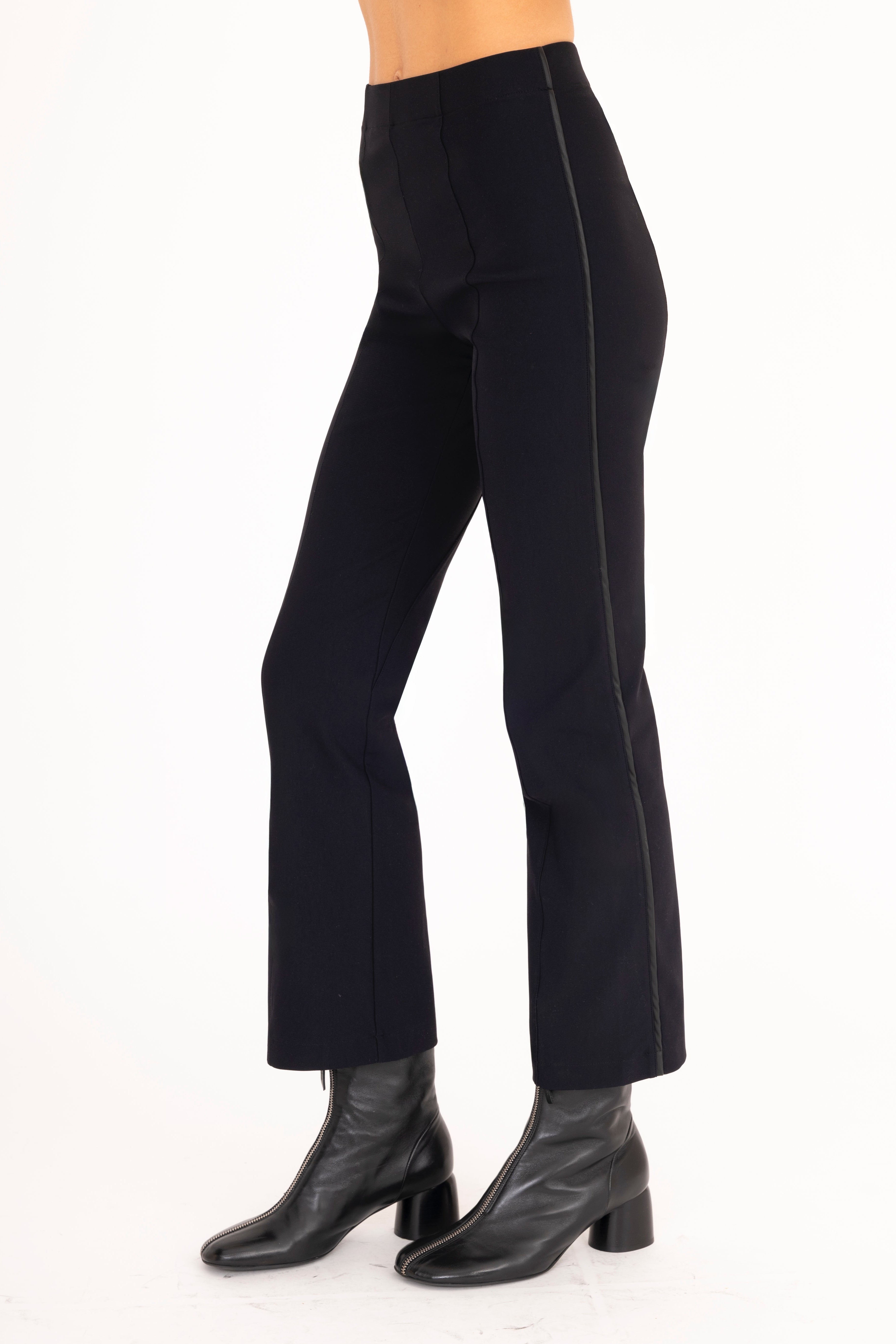 Black pants worn by a person on a white background