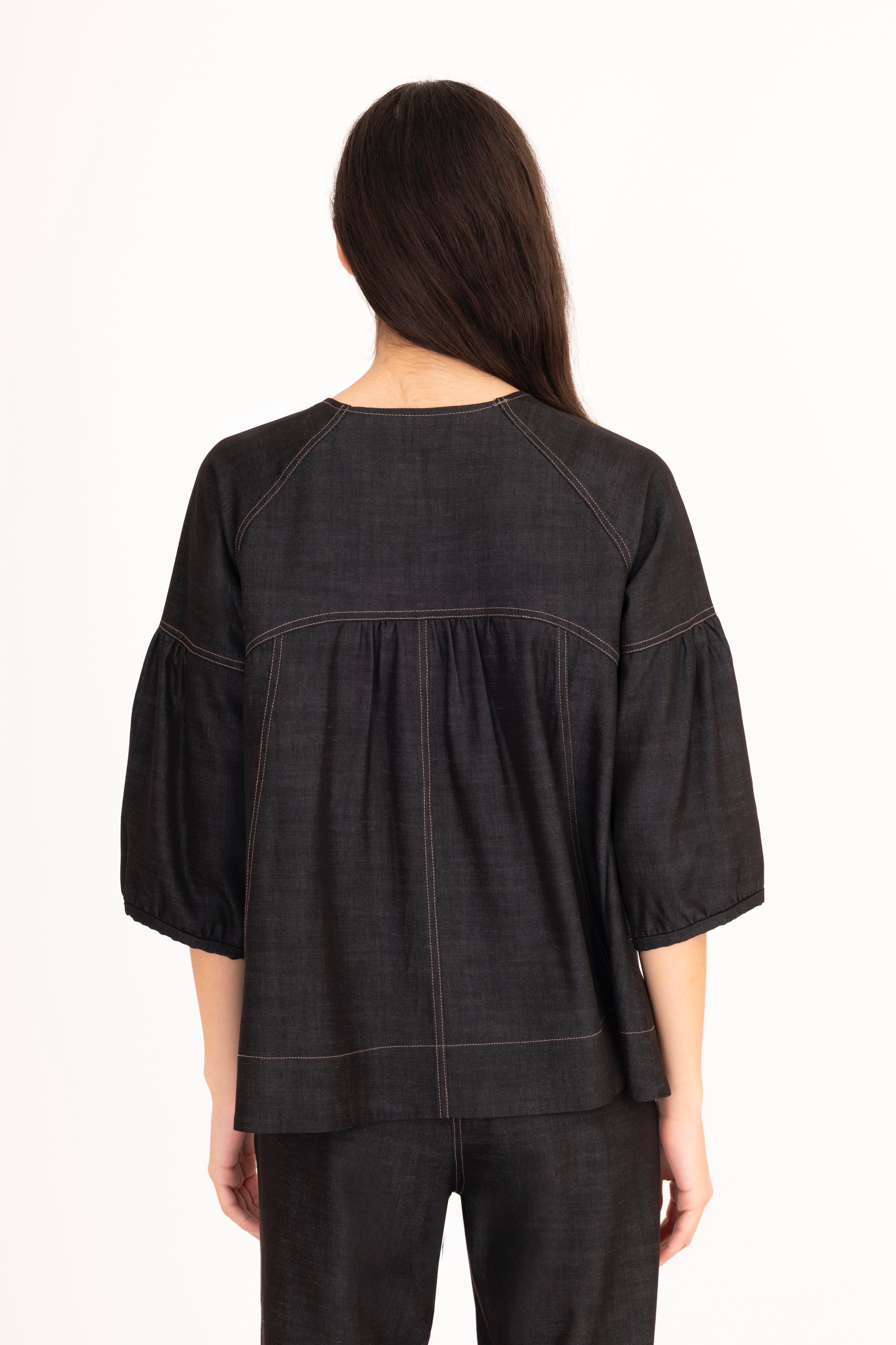 Woman wearing a black blouse and pants on a white background