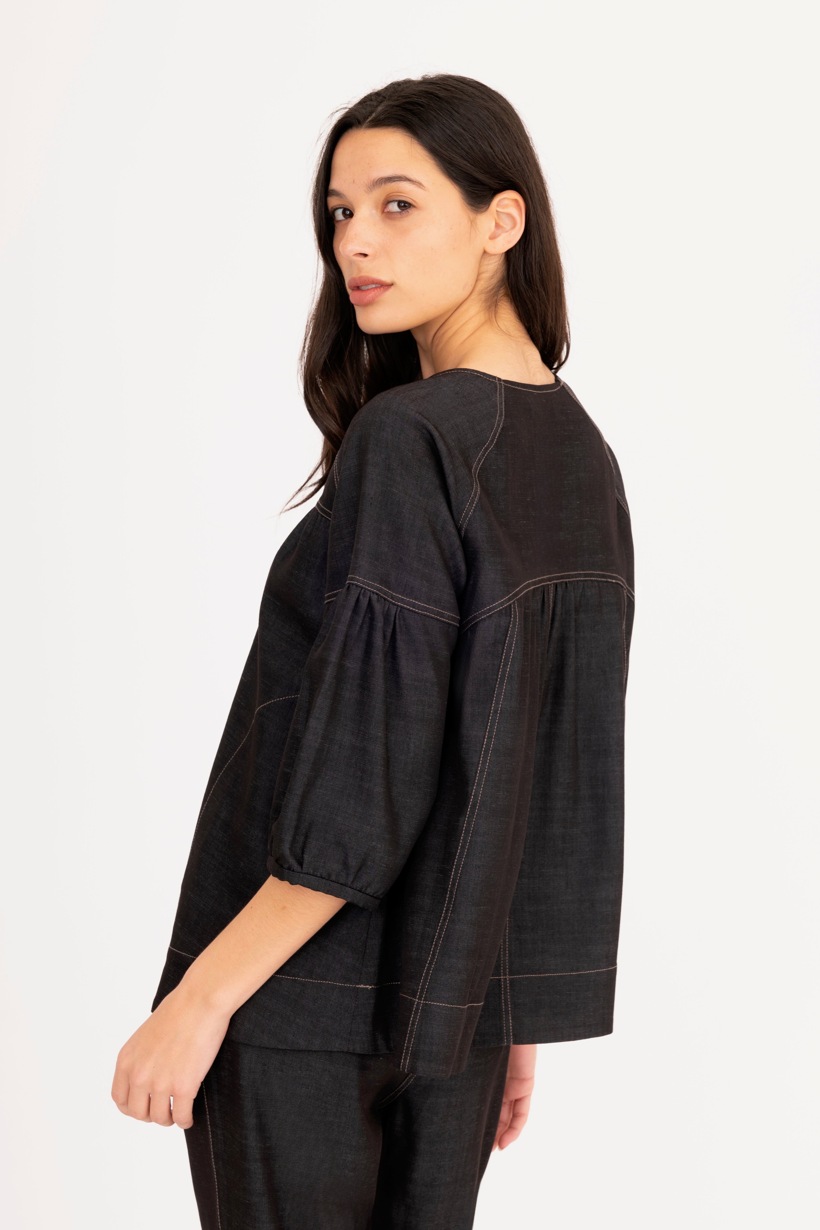 Woman wearing a black blouse and pants on a white background