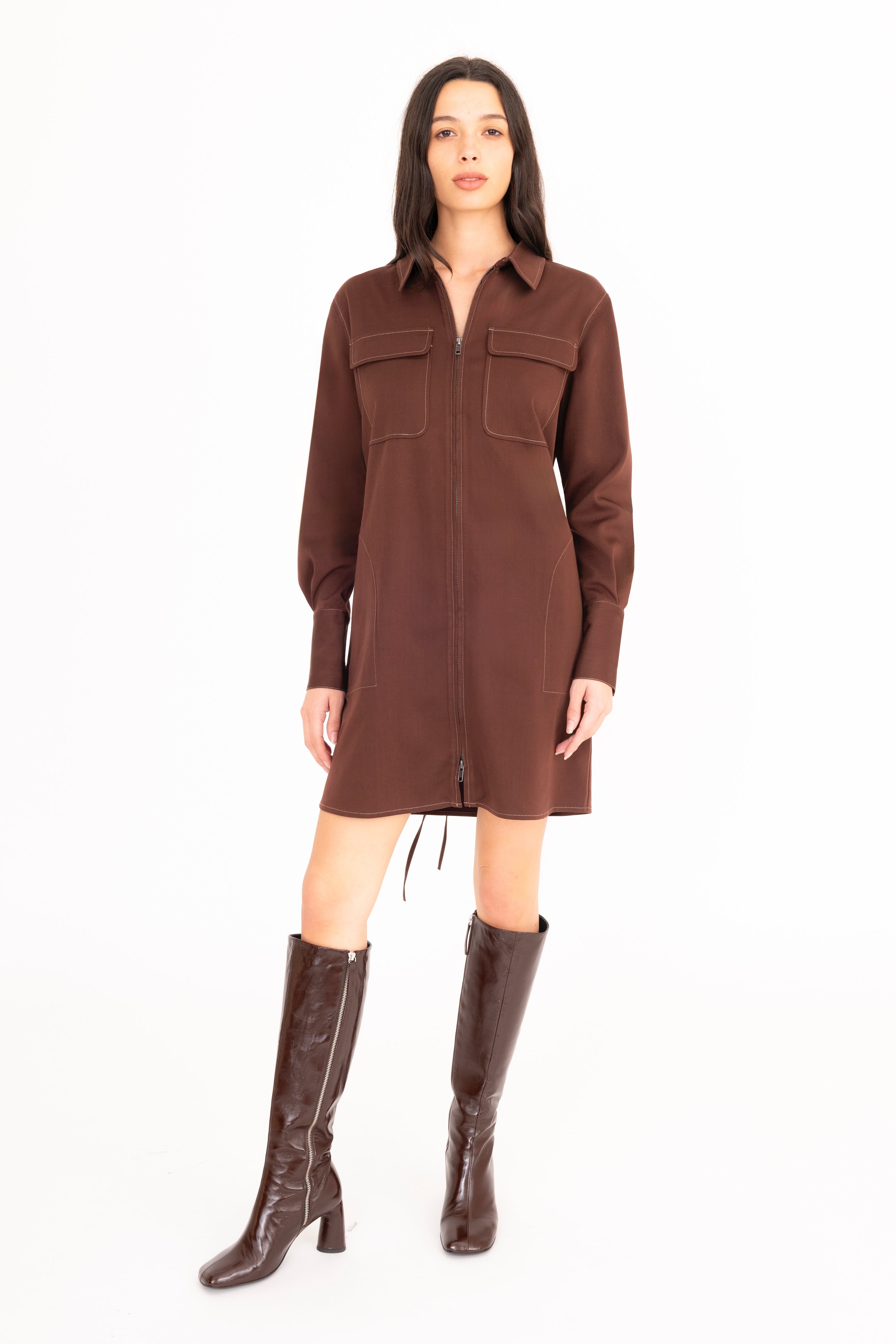 Woman wearing a brown dress with button details on a white background