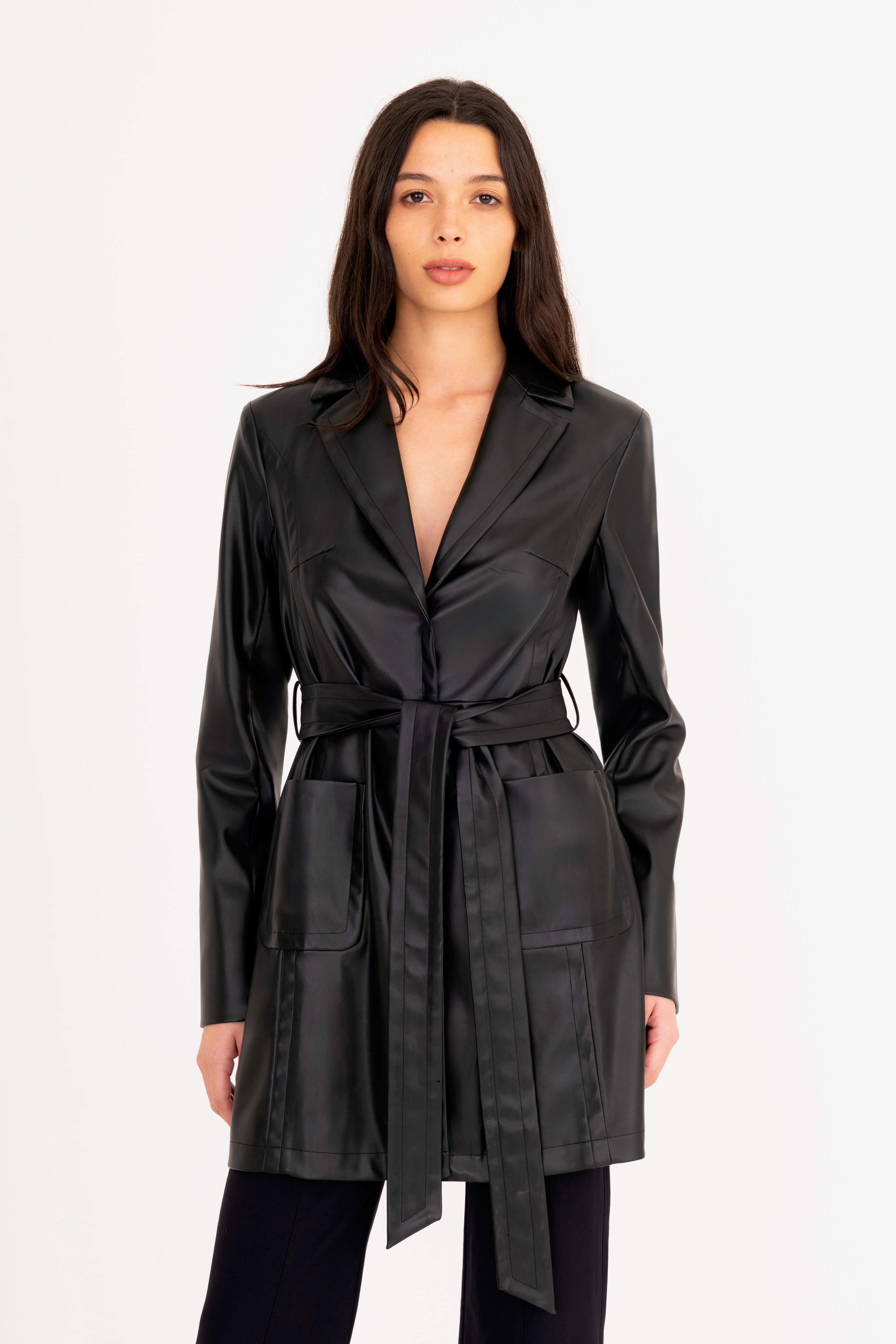 Woman wearing a black trench coat on a white background