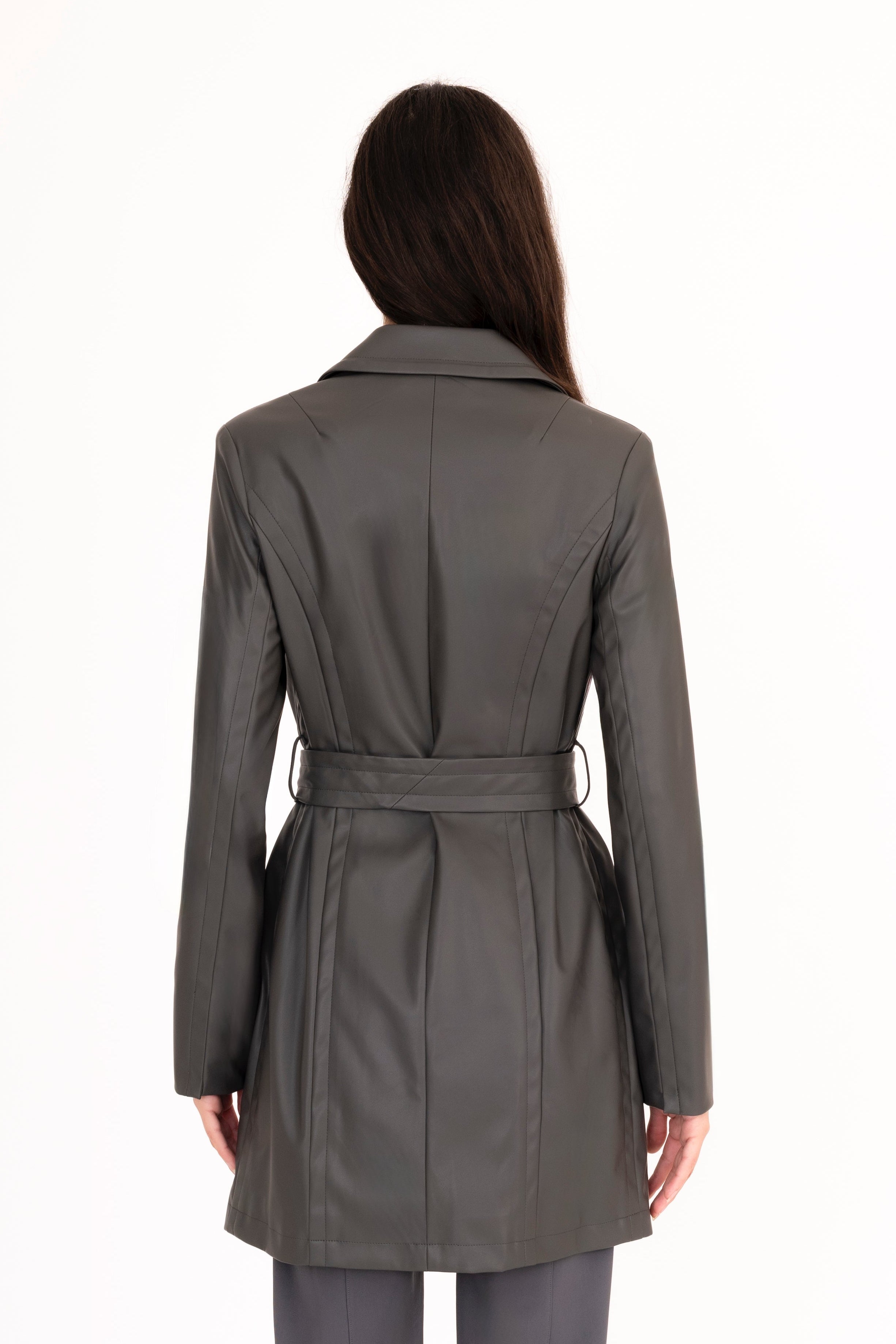 Woman wearing a gray trench coat and pants on a white background