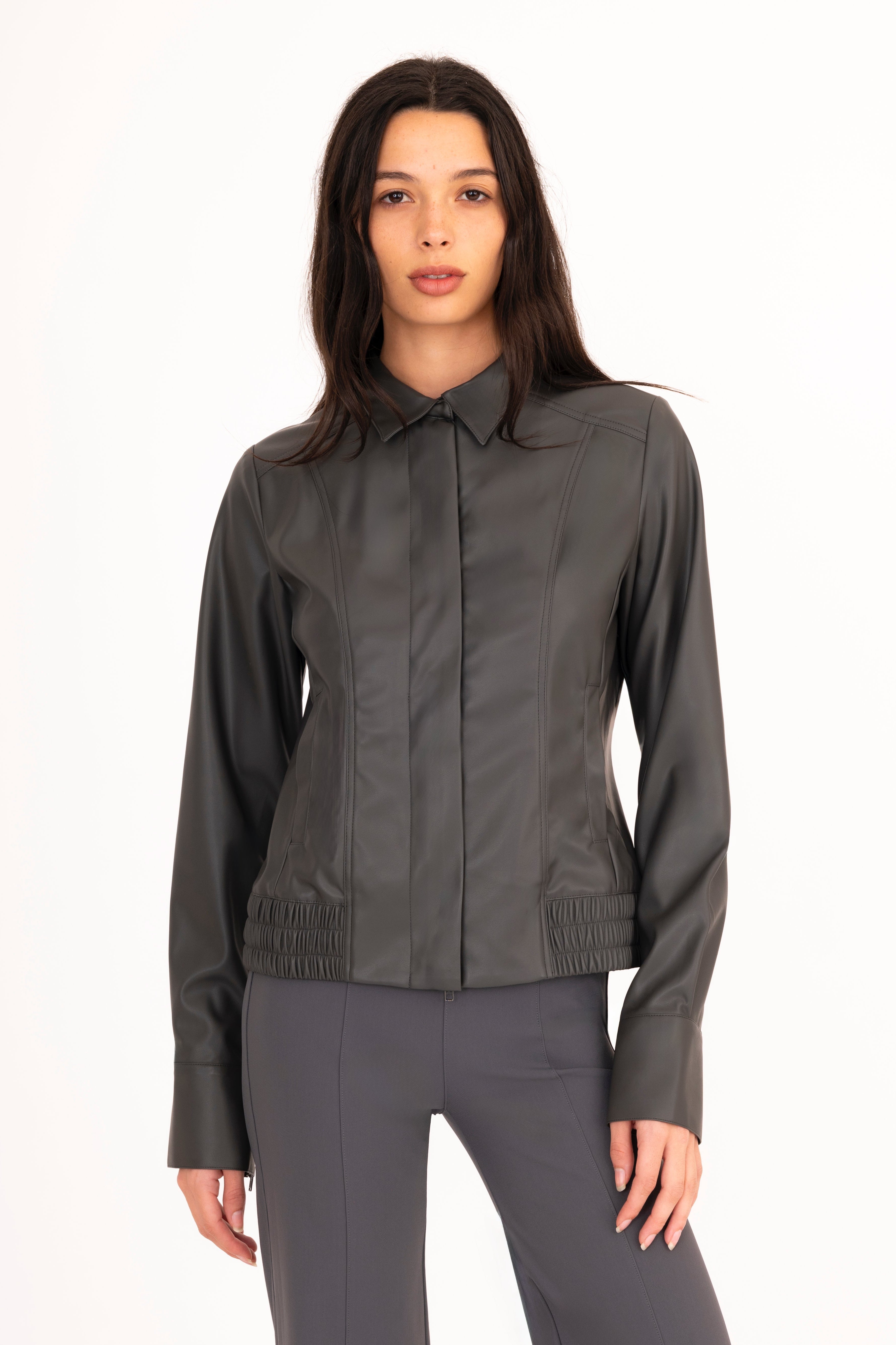 Woman wearing a dark gray jacket and pants on a white background