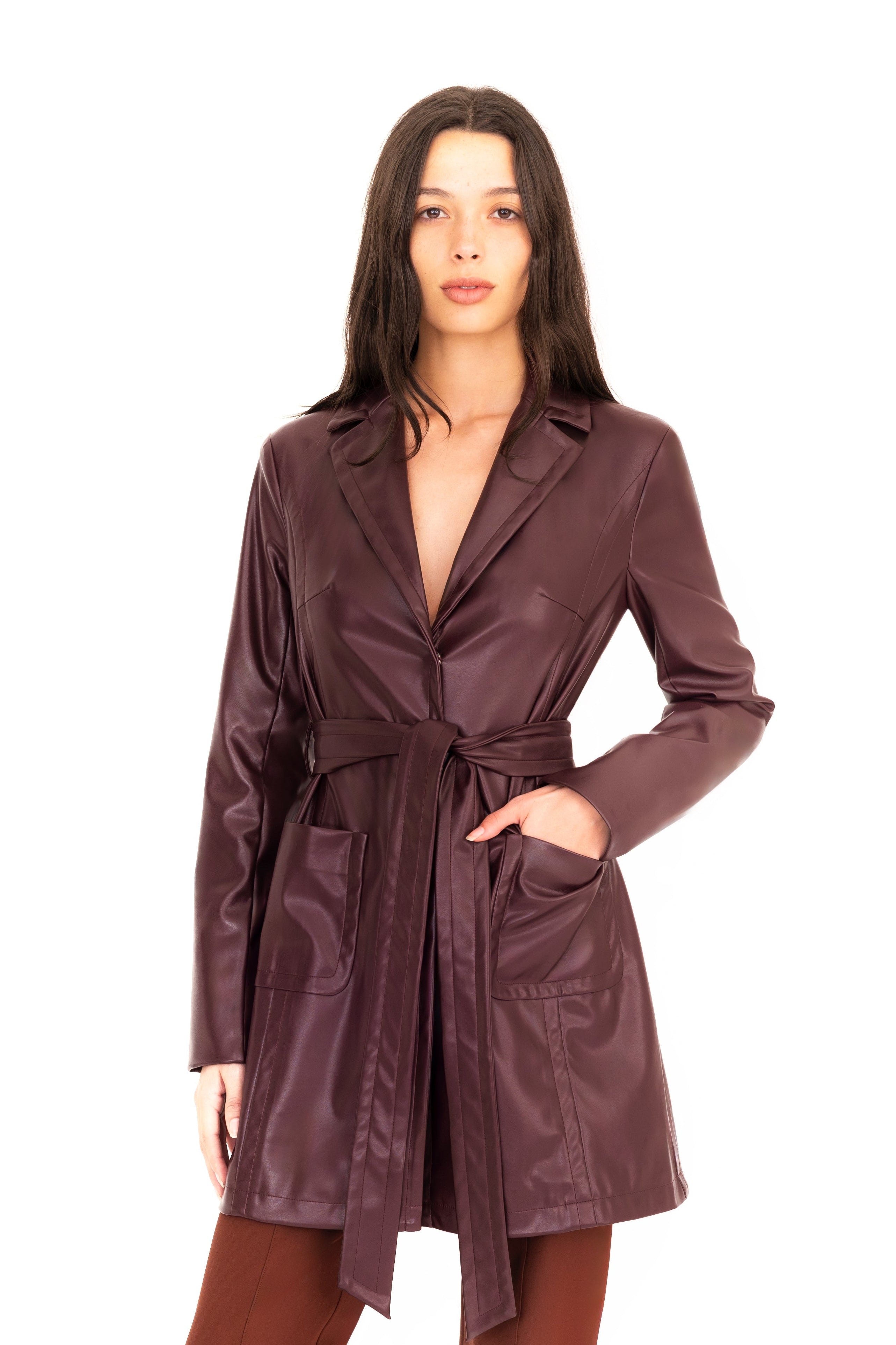 Woman wearing a burgundy trench coat and pants on a white
