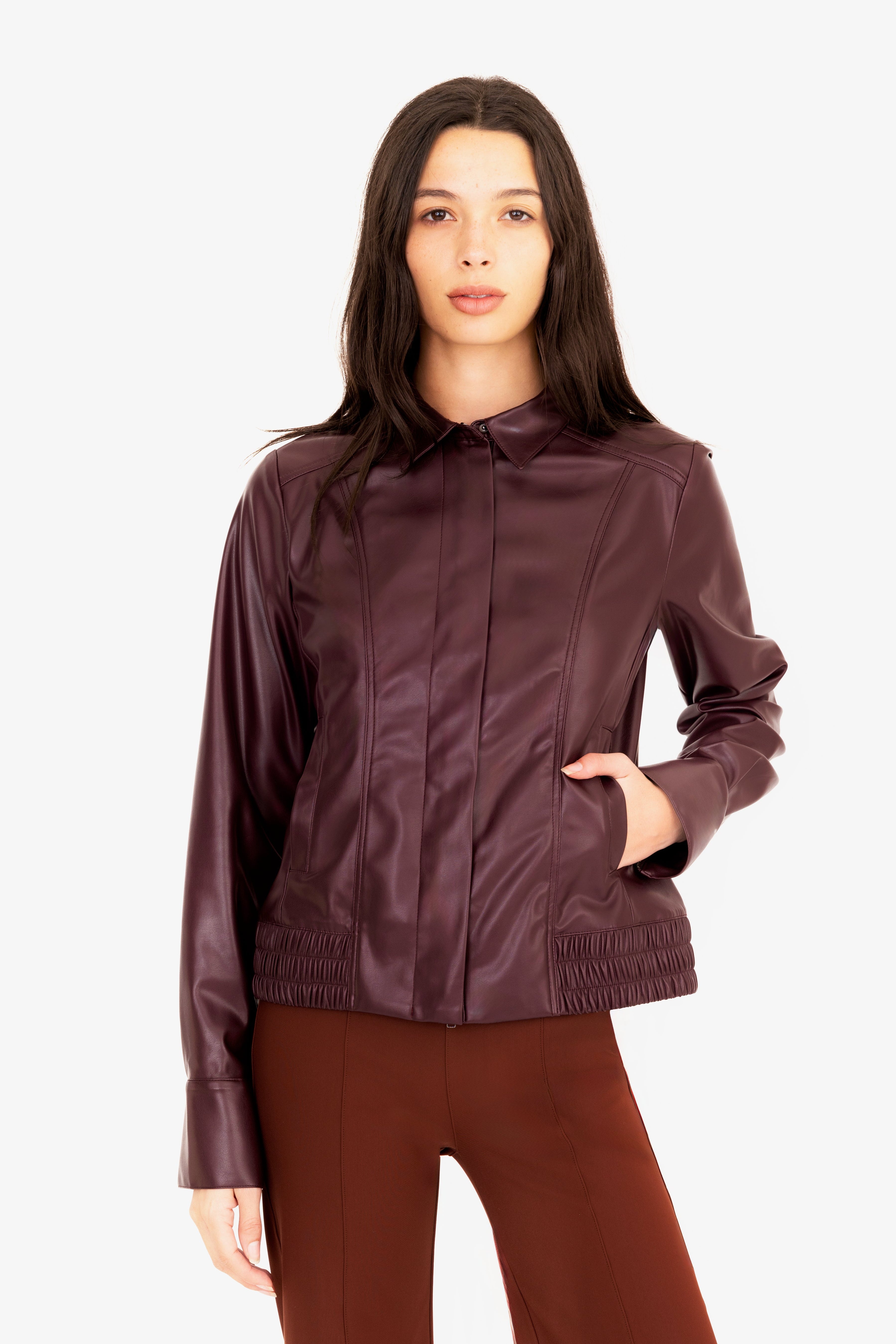 Woman wearing a brown leather jacket on a white background