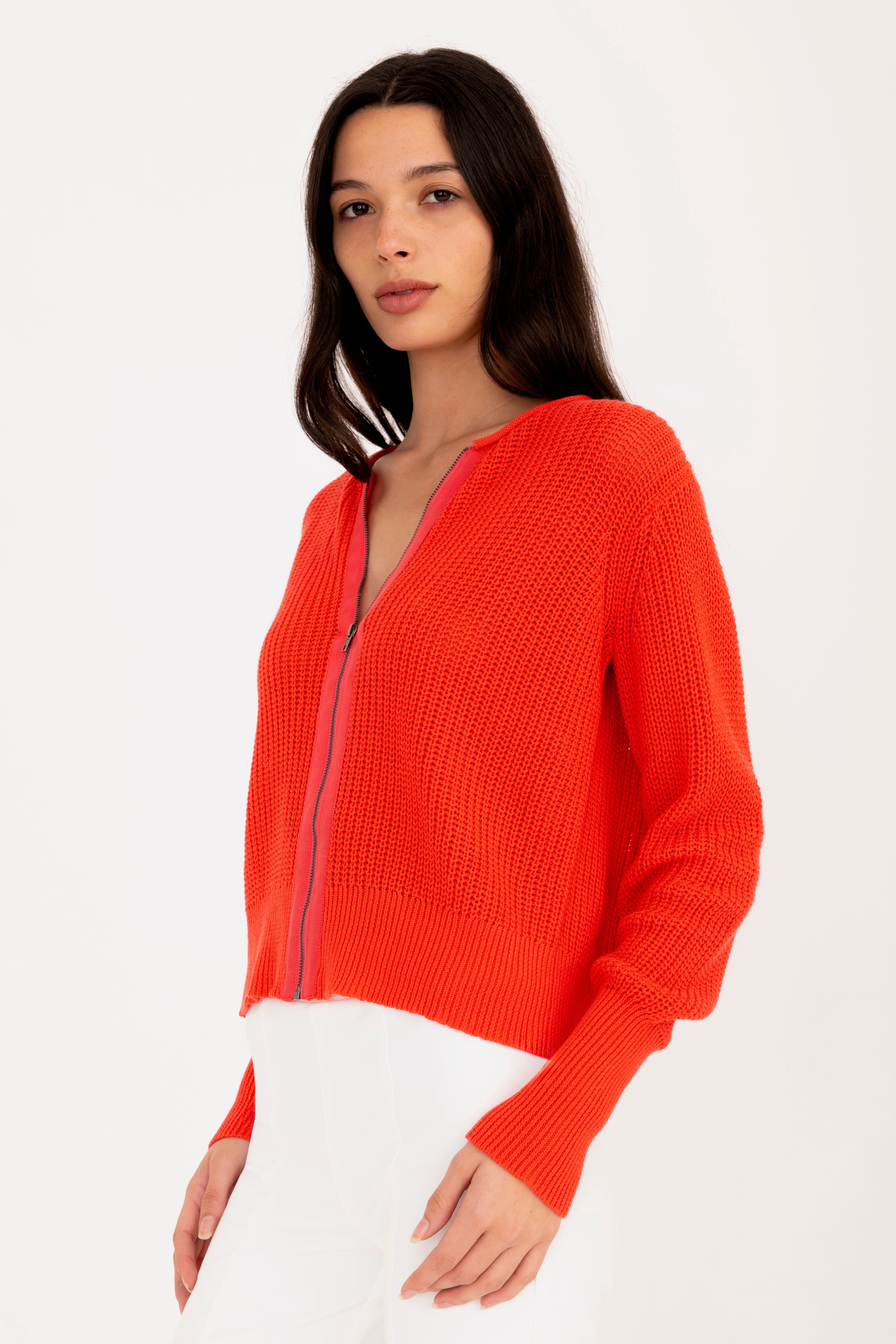 Woman wearing a orange sweater on a white background