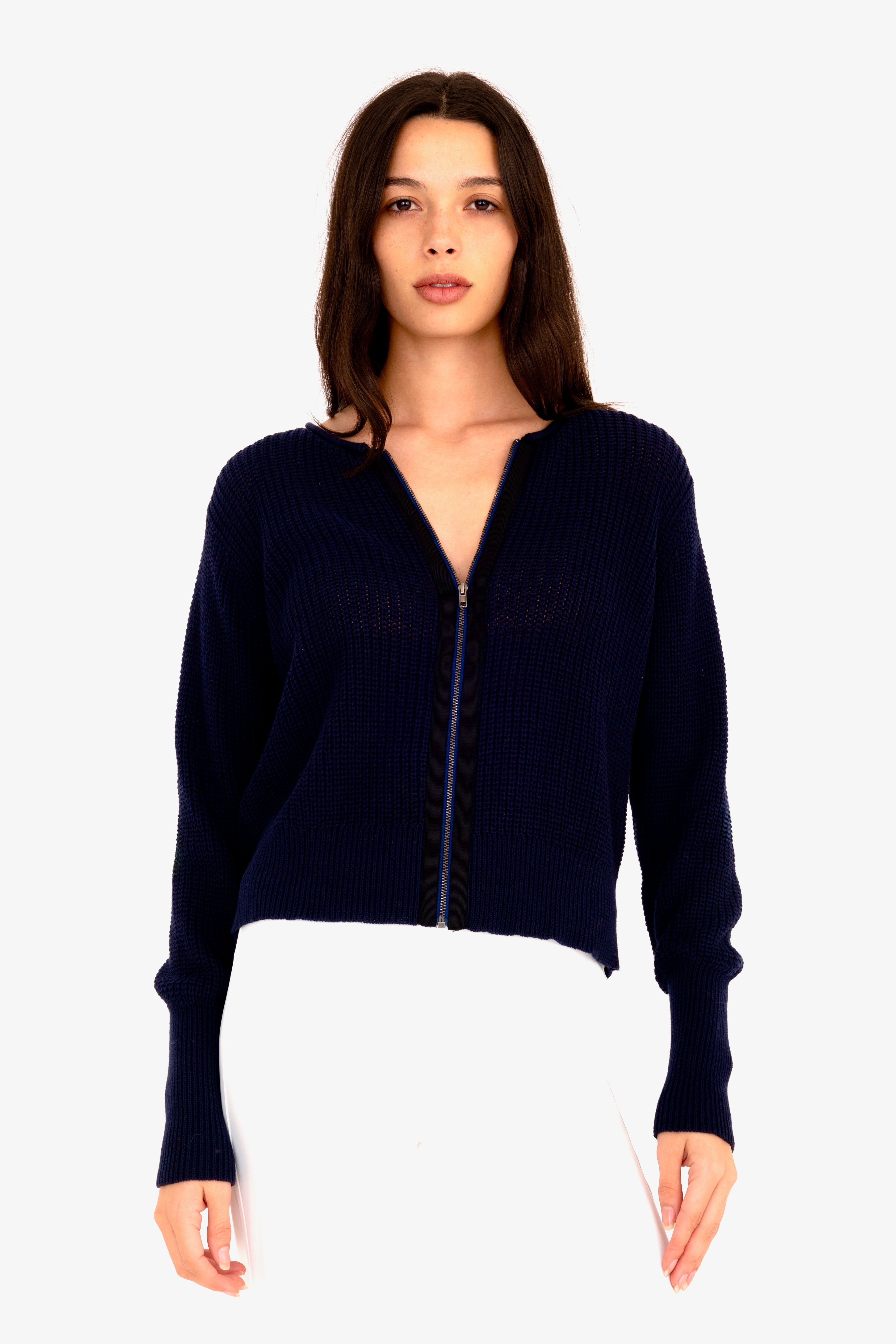 Woman wearing a navy blue zip-up sweater on a white background