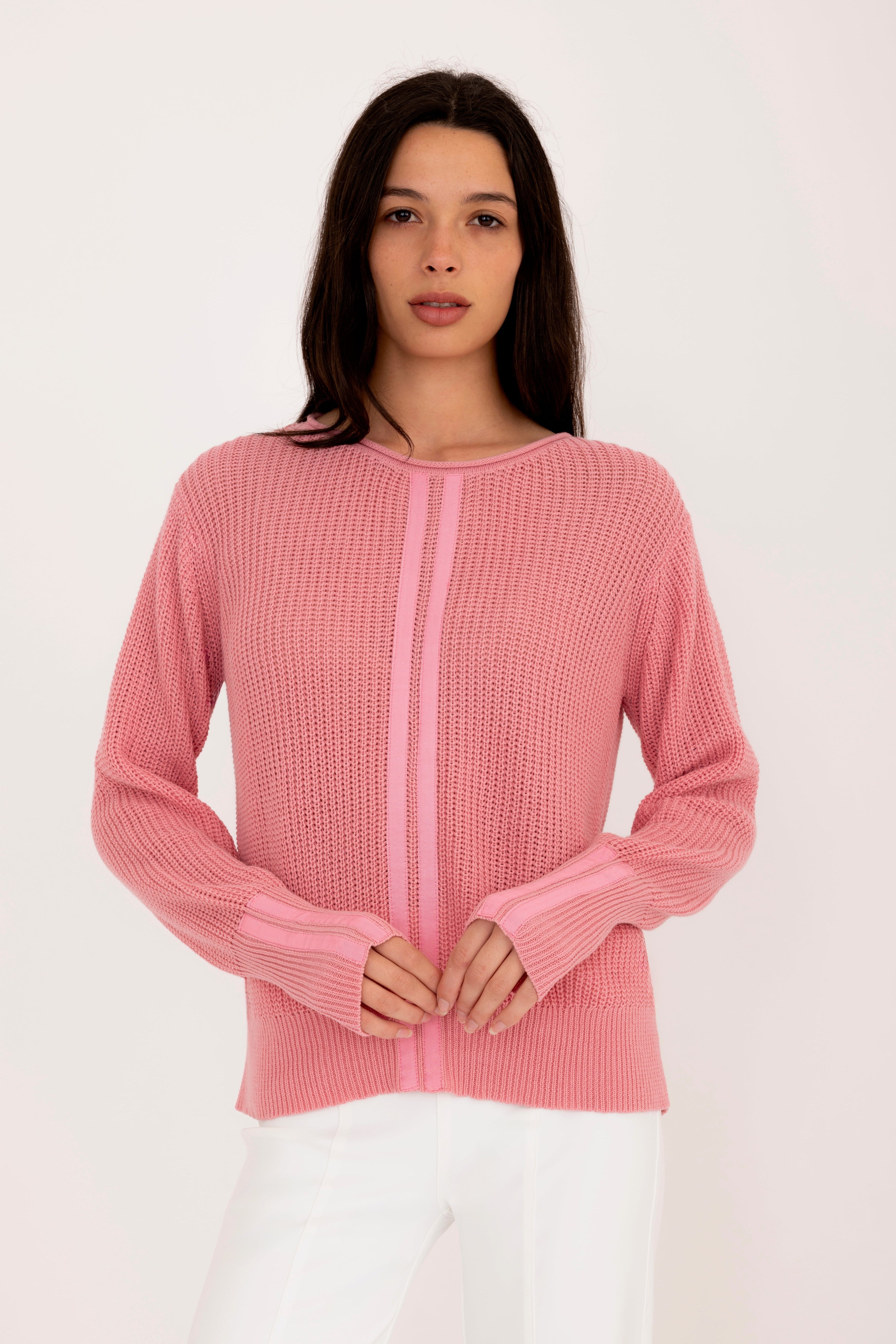 Woman wearing a pink sweater on a white background
