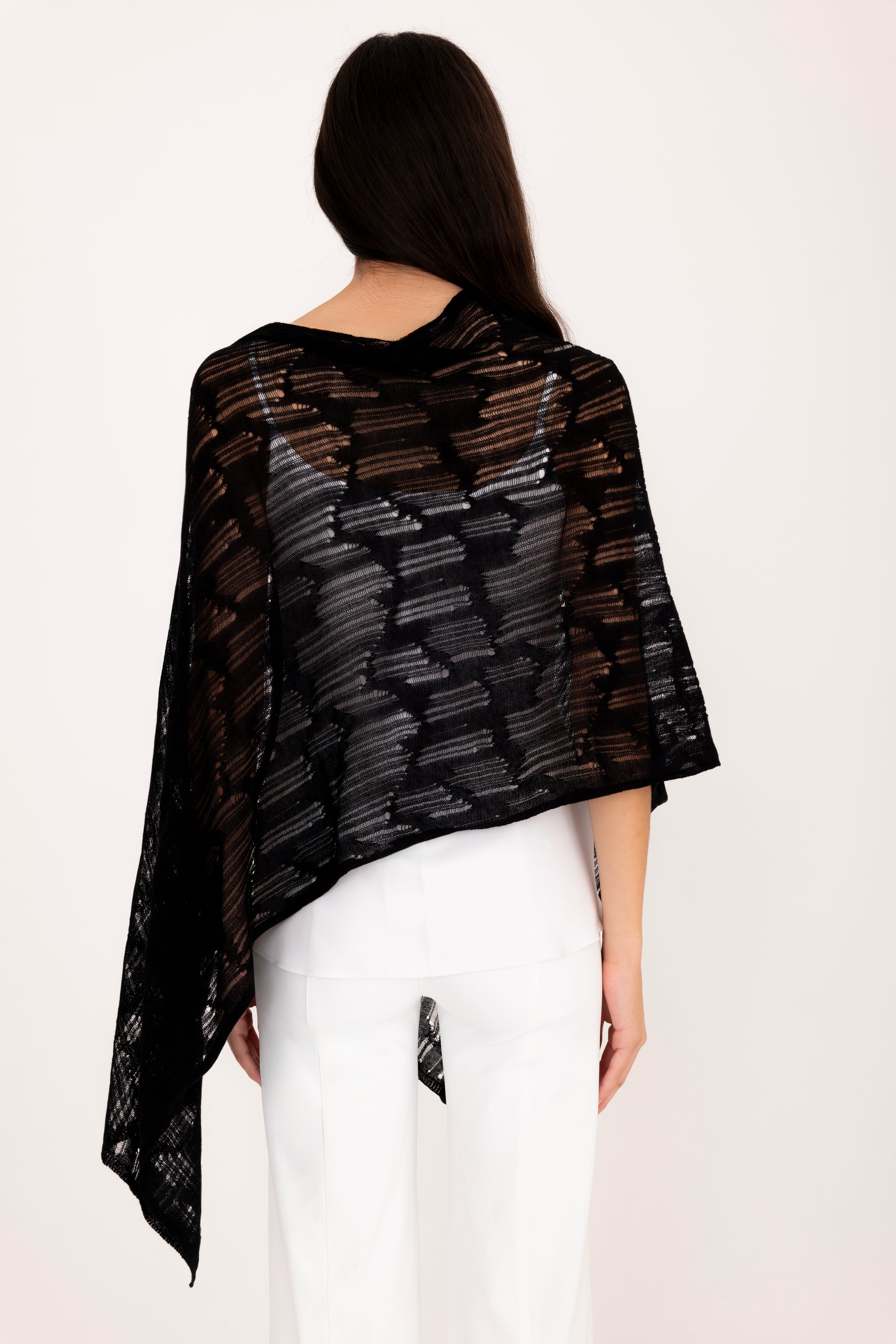 Woman wearing a black poncho top on a white background