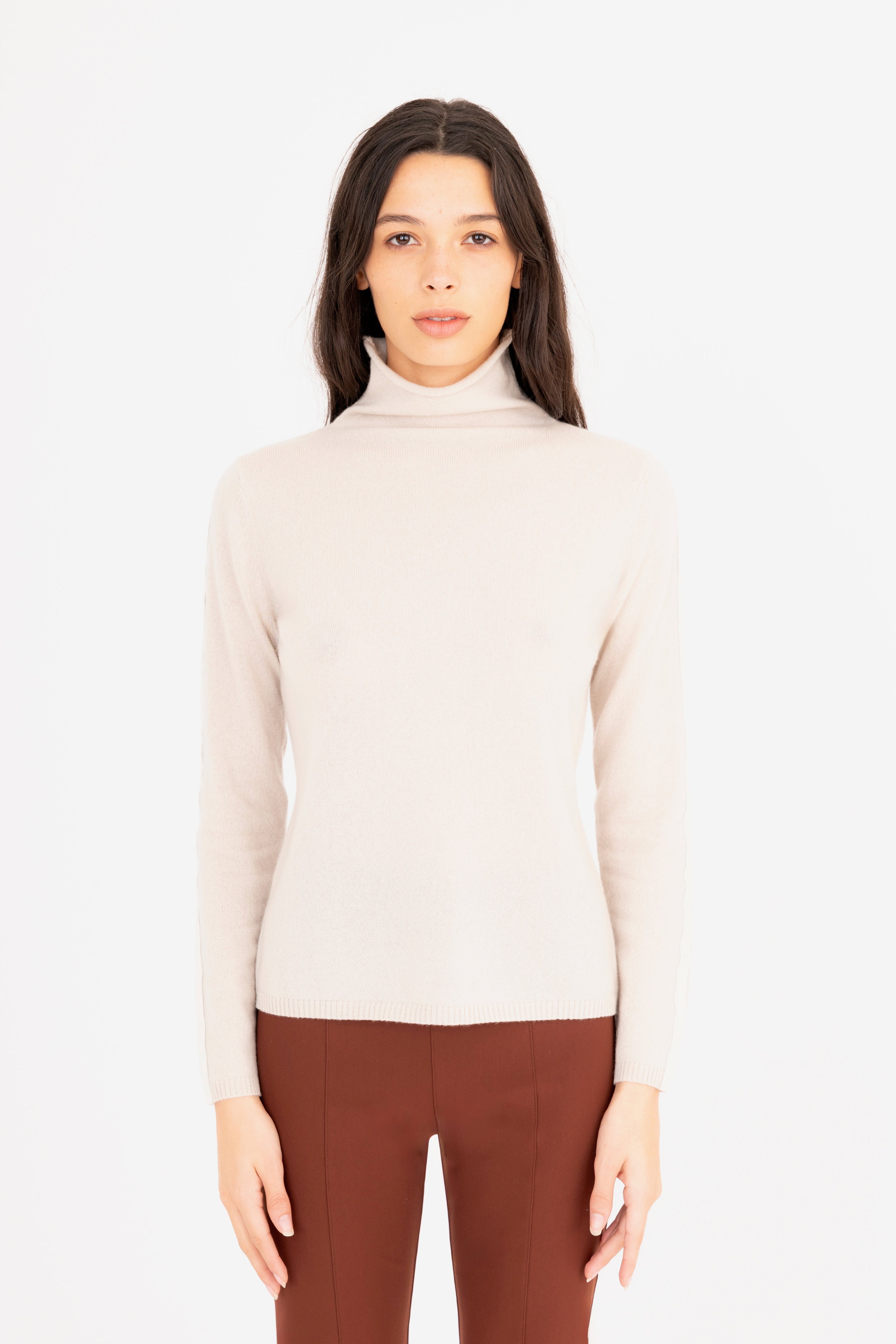 Woman wearing a beige turtleneck sweater on a white background