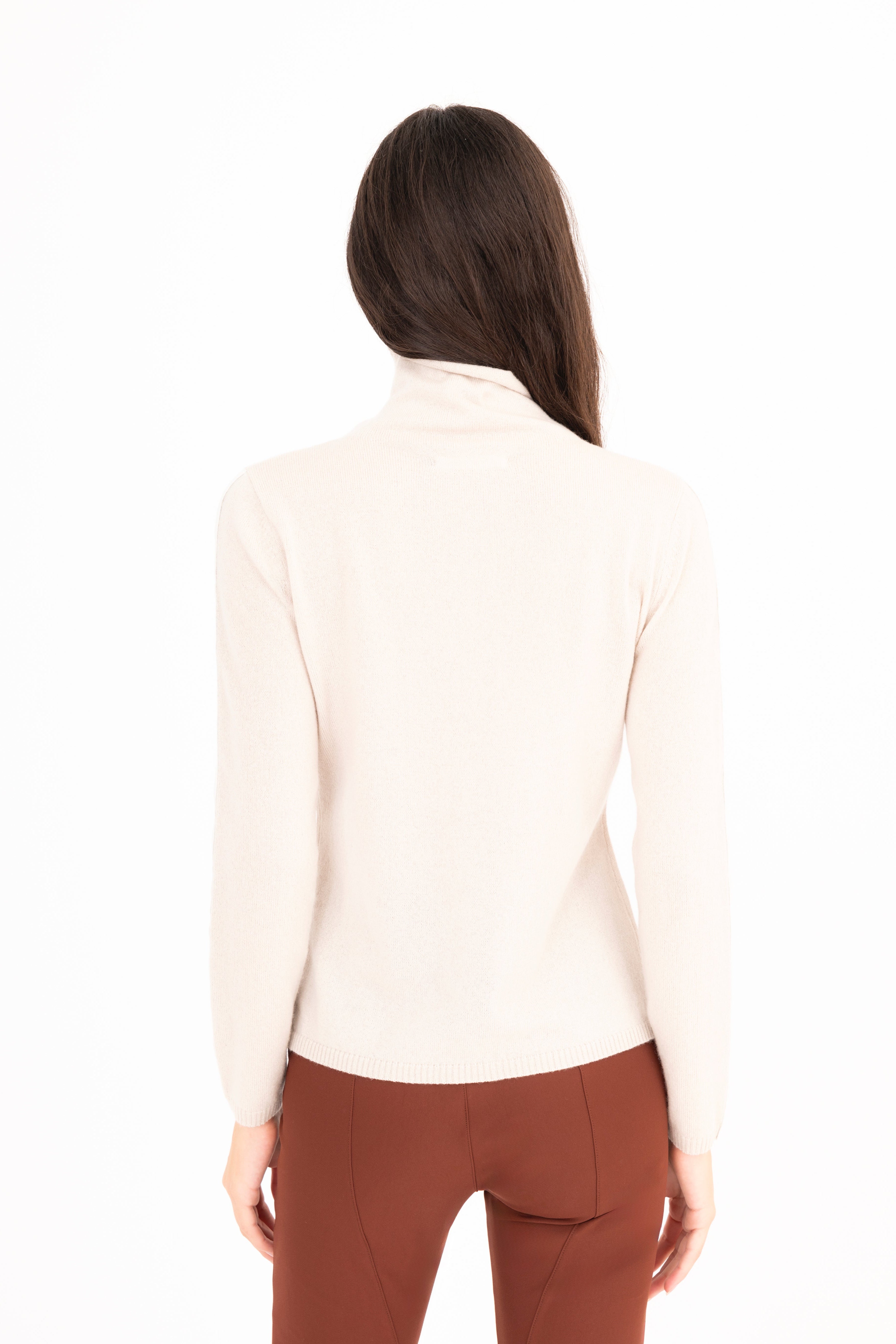 Woman wearing a beige turtleneck sweater on a white background