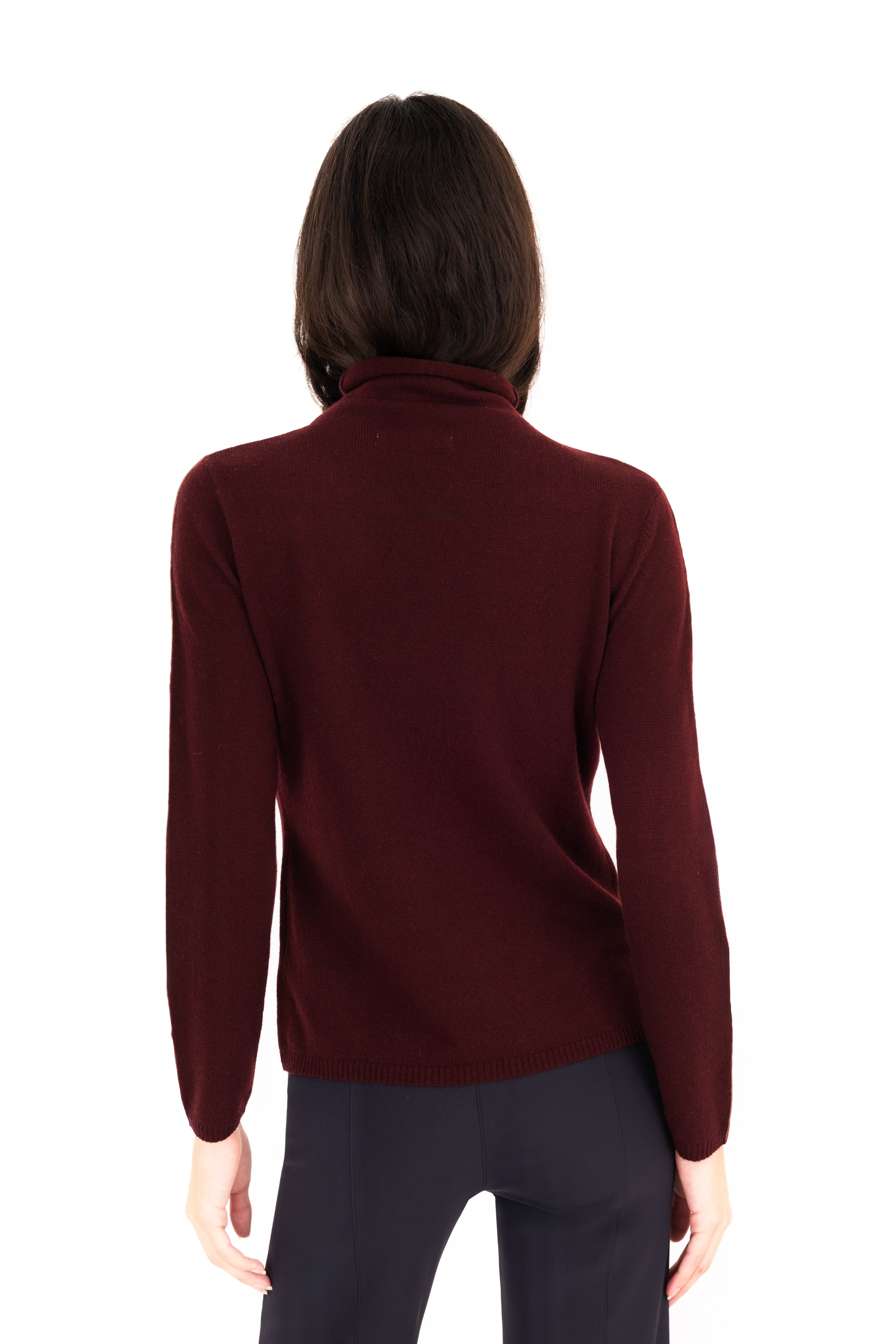 Woman wearing a burgundy turtleneck sweater on a white