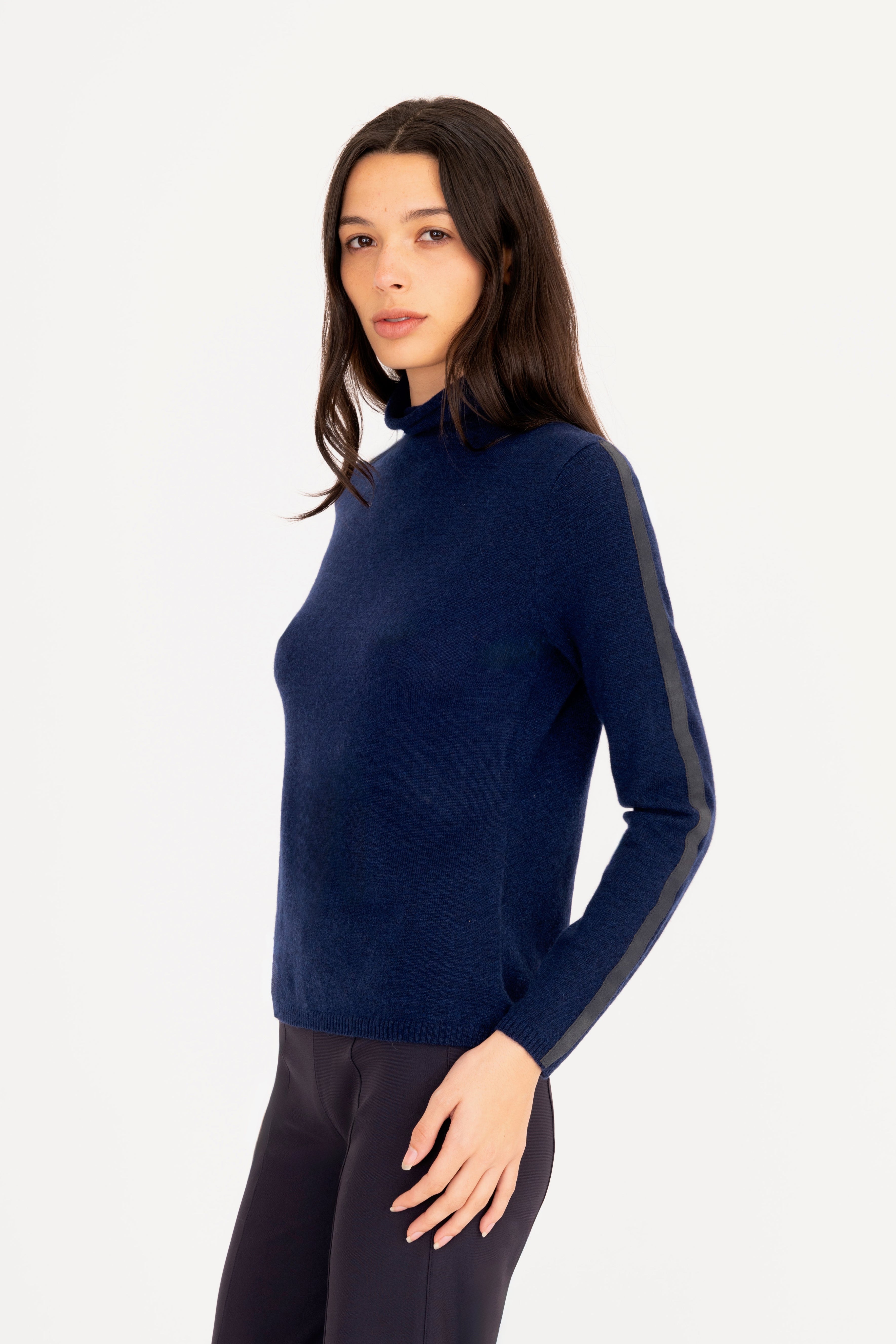 Woman wearing a navy blue turtleneck sweater on a white background