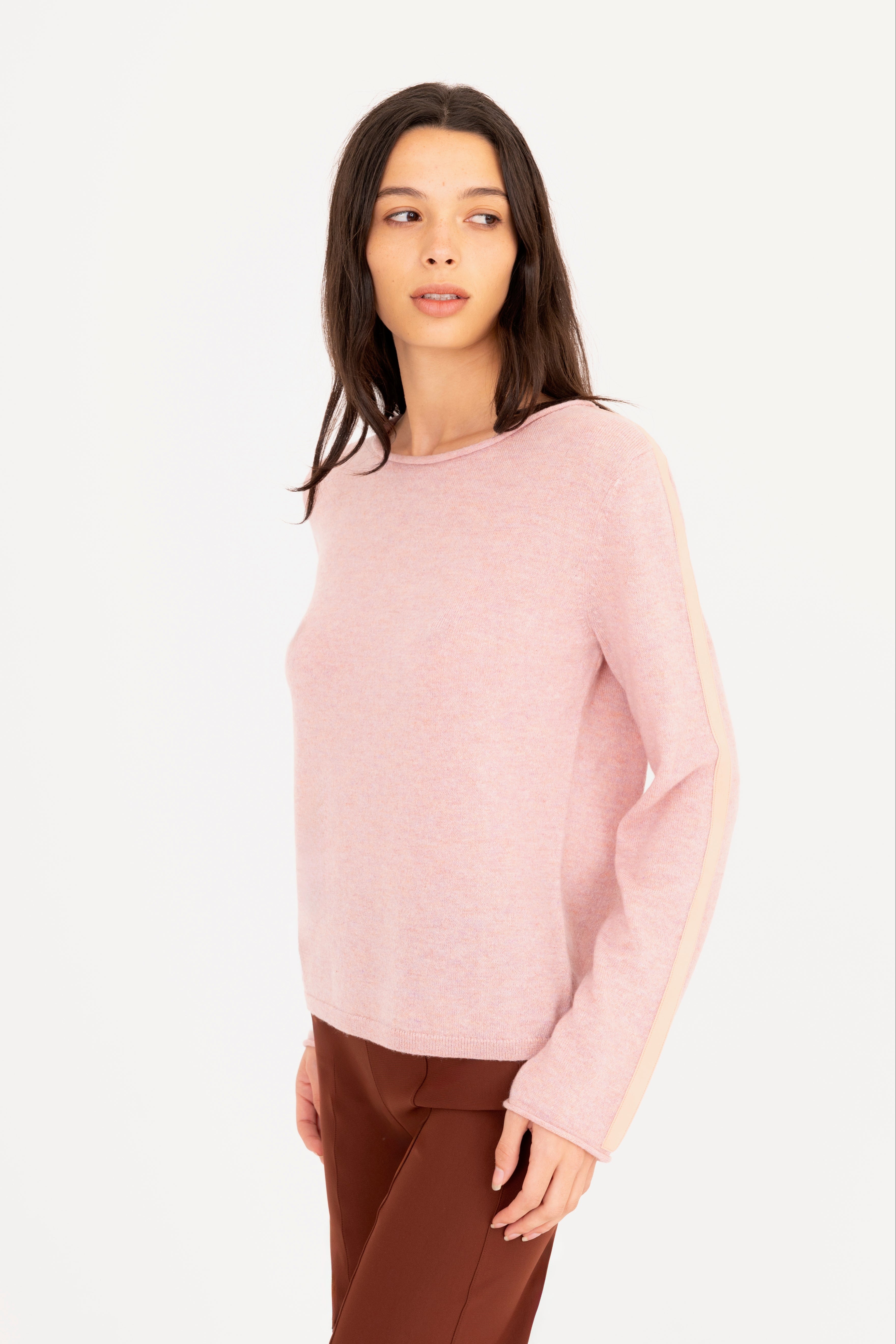 Woman wearing a pink sweater on a white background