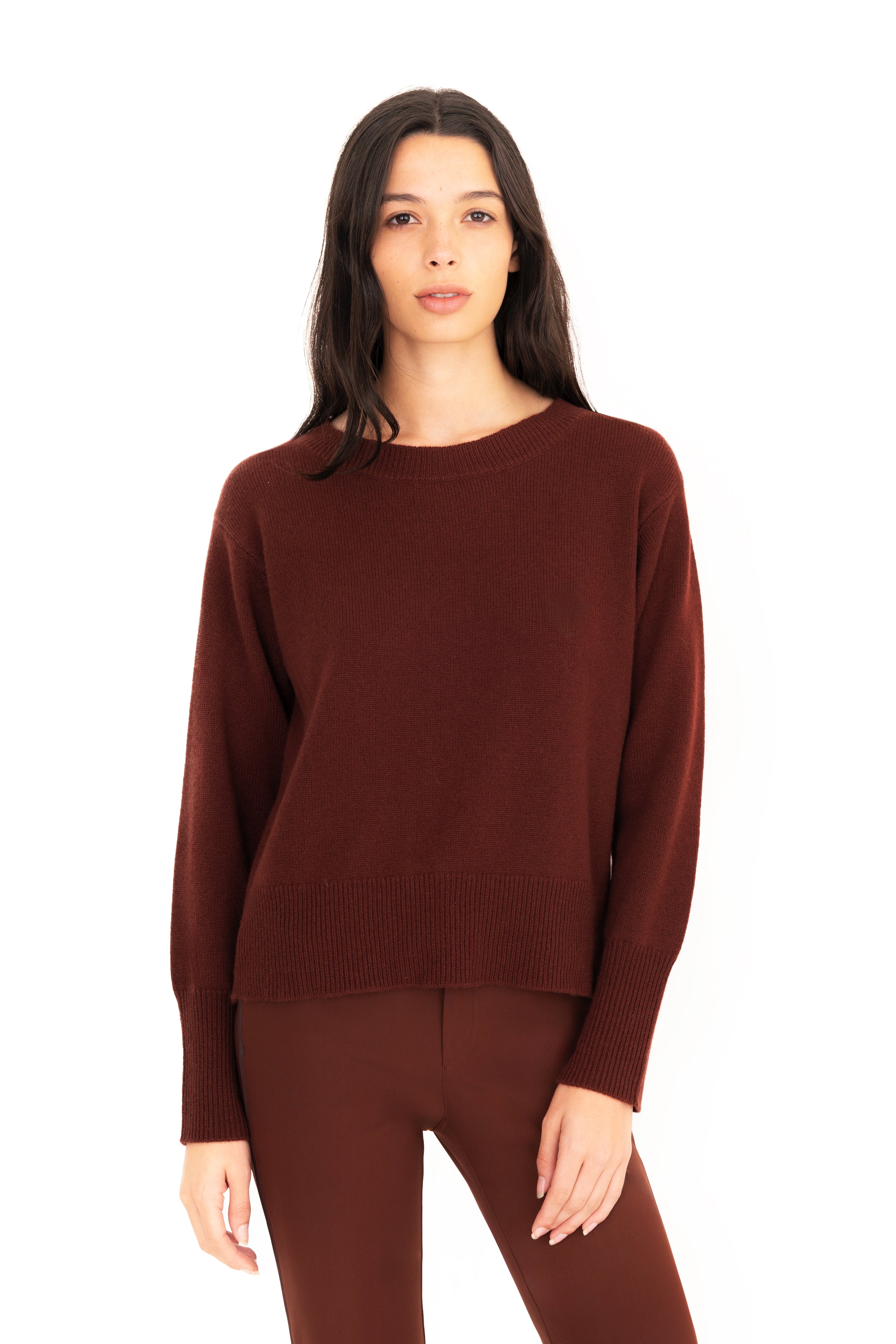 Woman wearing a brown sweater and pants on a white background