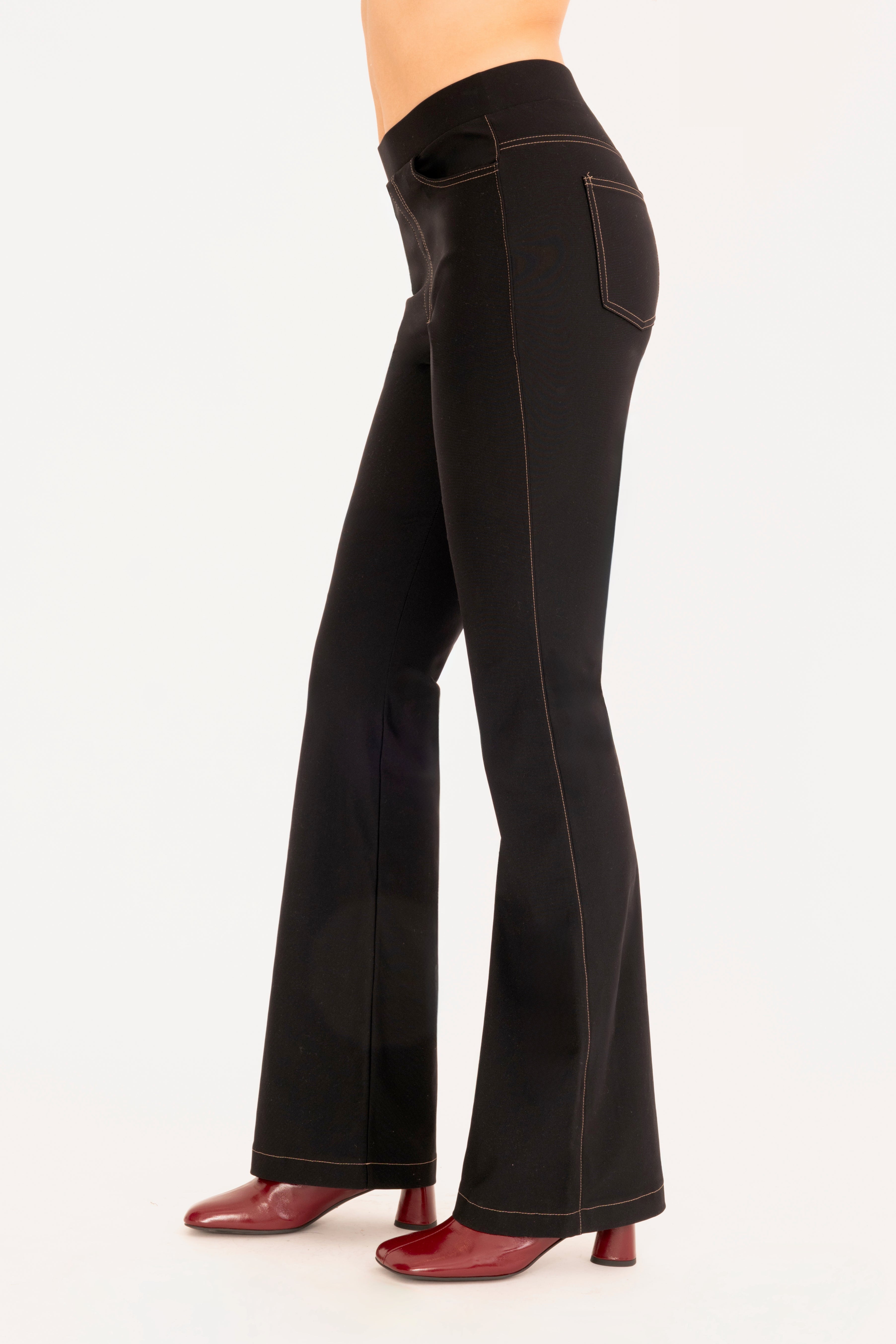 Side view of black flare jean pants on a white background