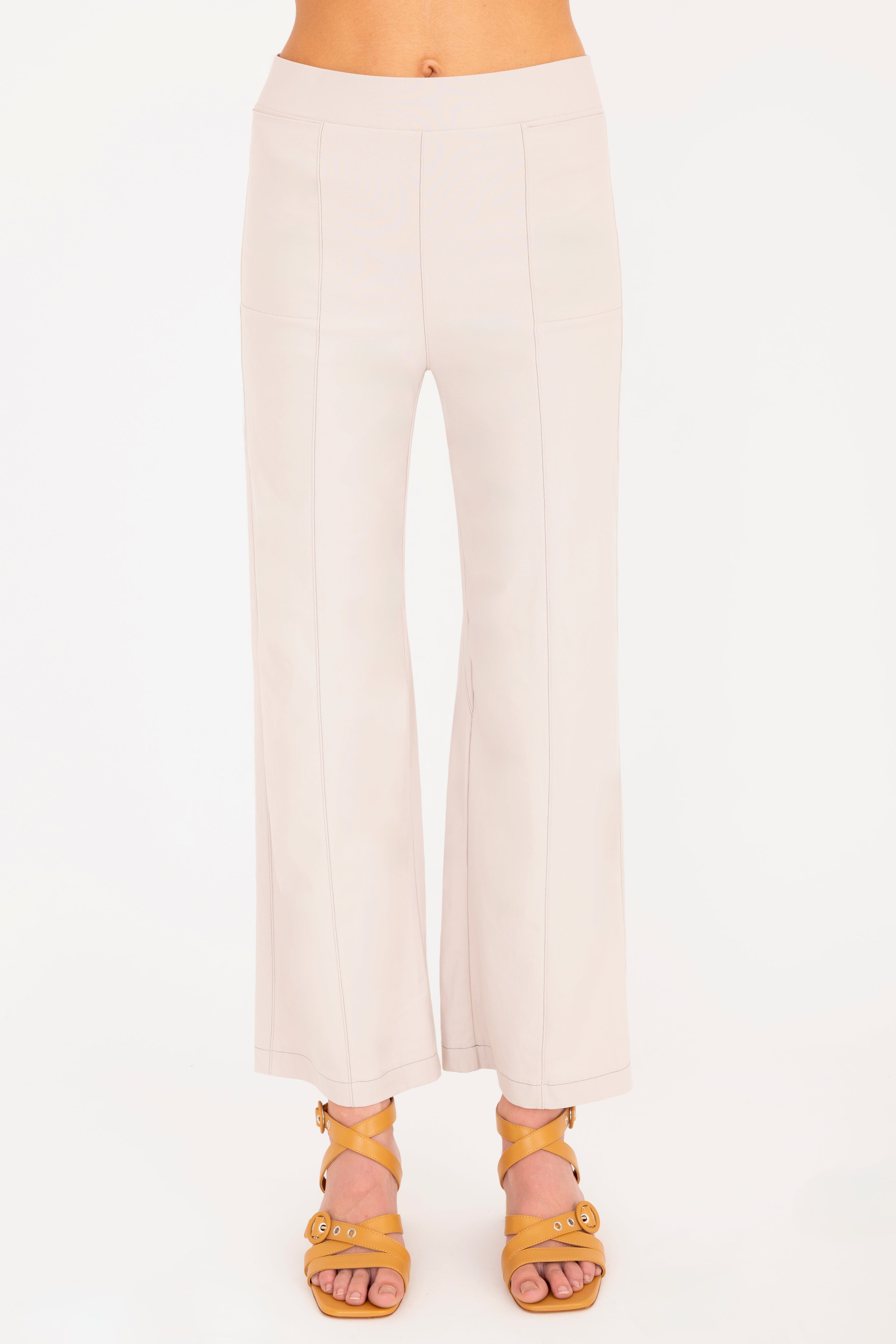 Beige pants worn by a person on a white background