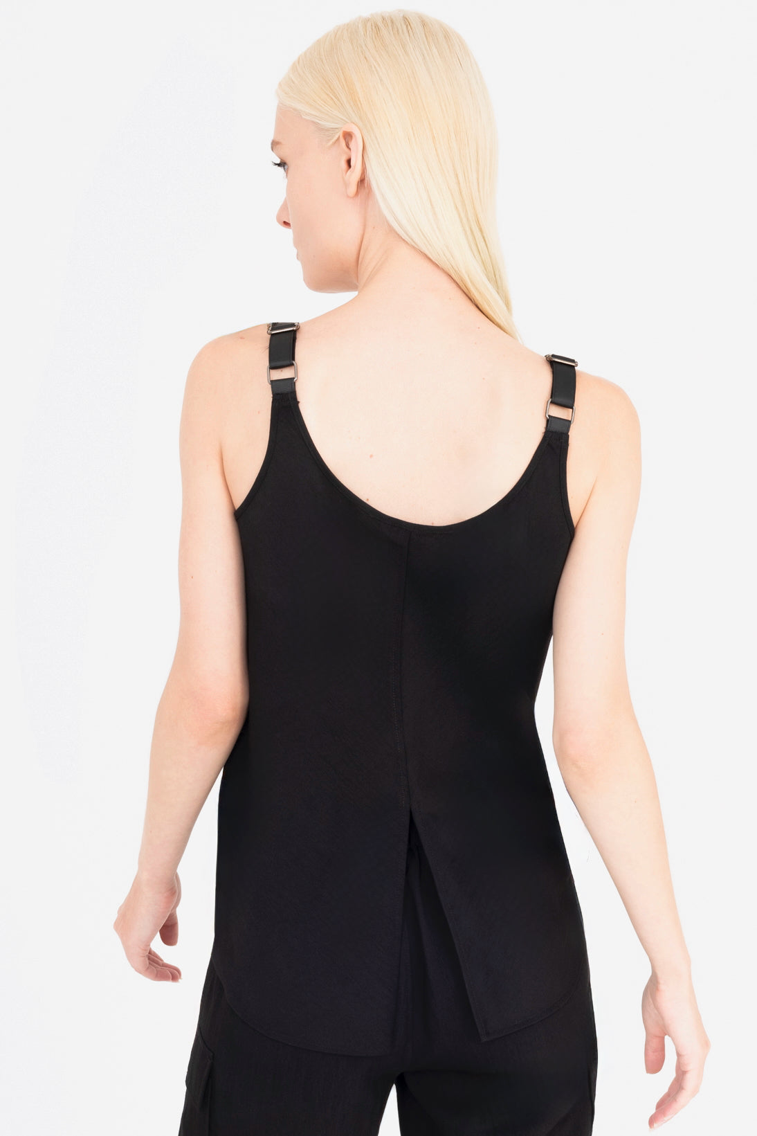 Woman wearing a black sleeveless top with a ruched design on a white background