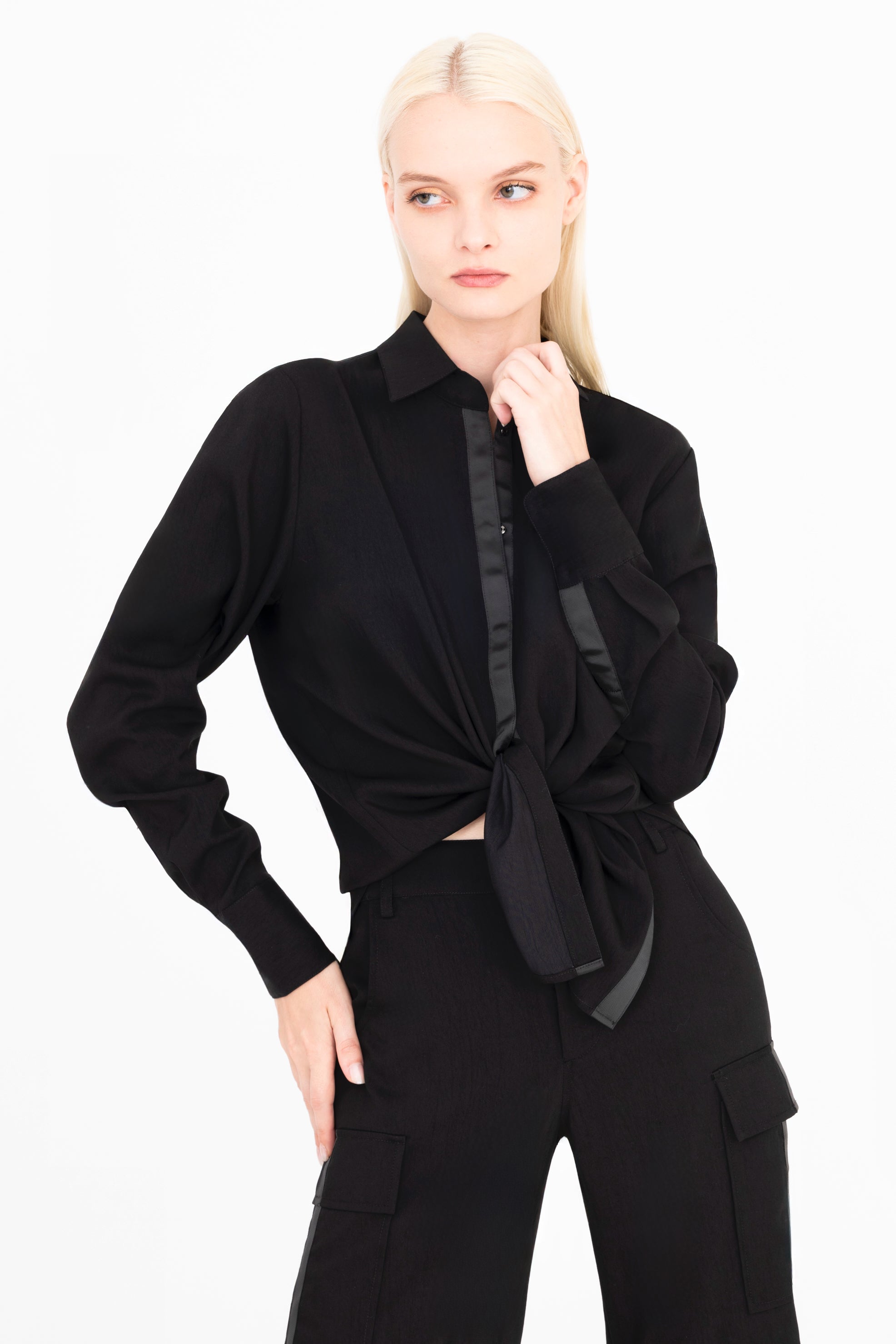 Front view of woman wearing a black shirt and pants on a white background