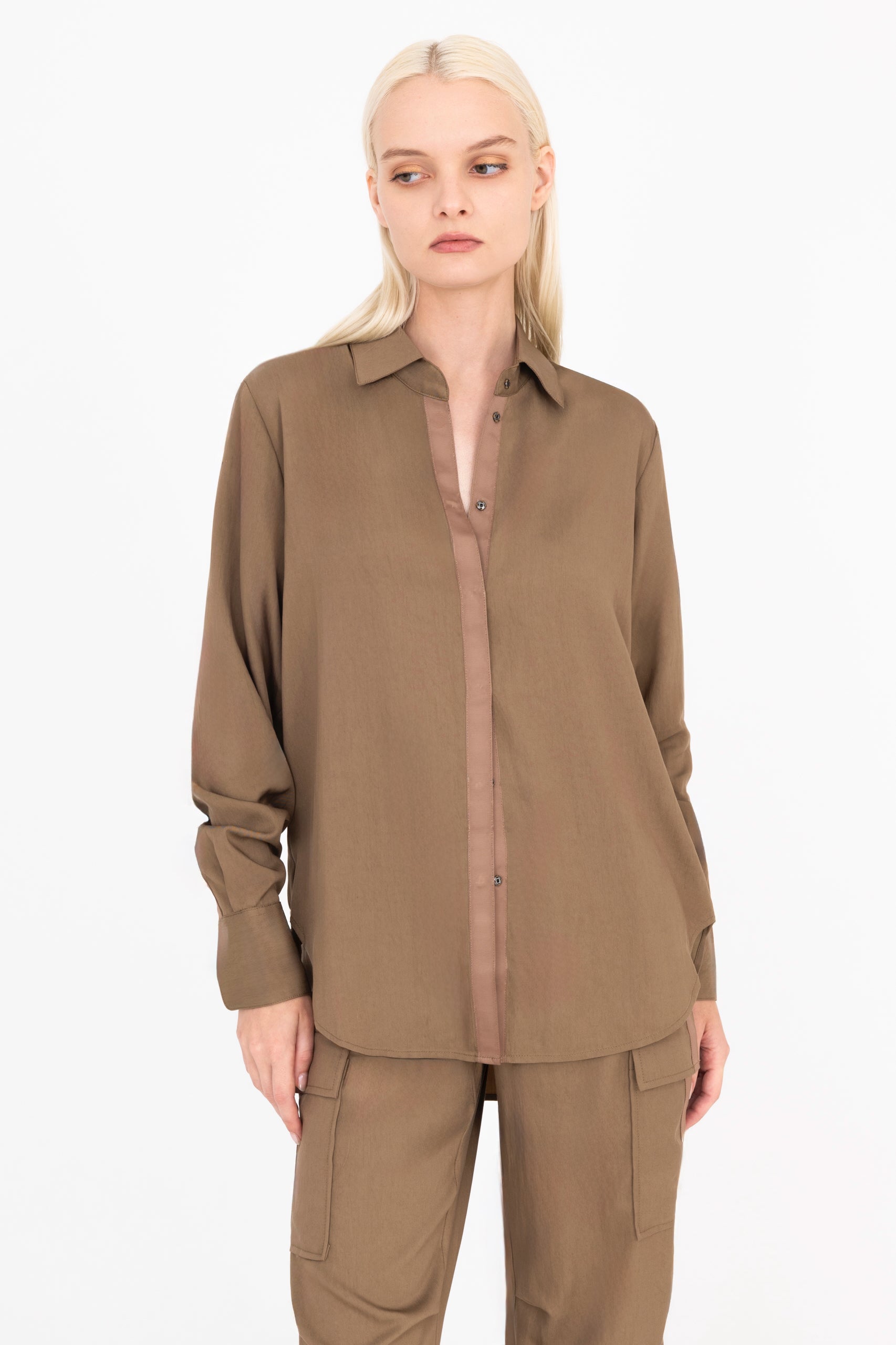 Front view of woman wearing a brown shirt and pants on a white background