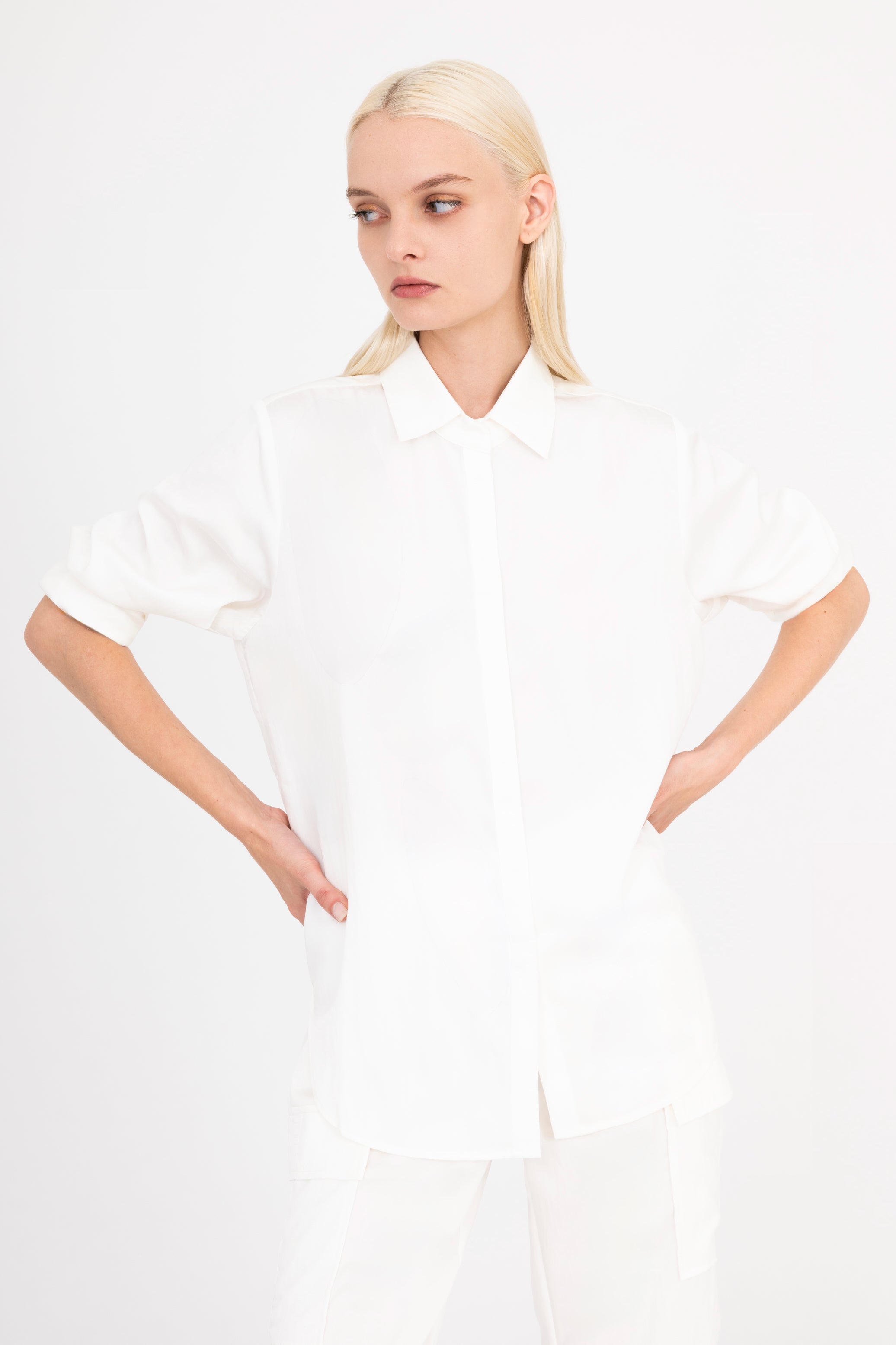 Front view of woman wearing a white shirt and pants on a white background
