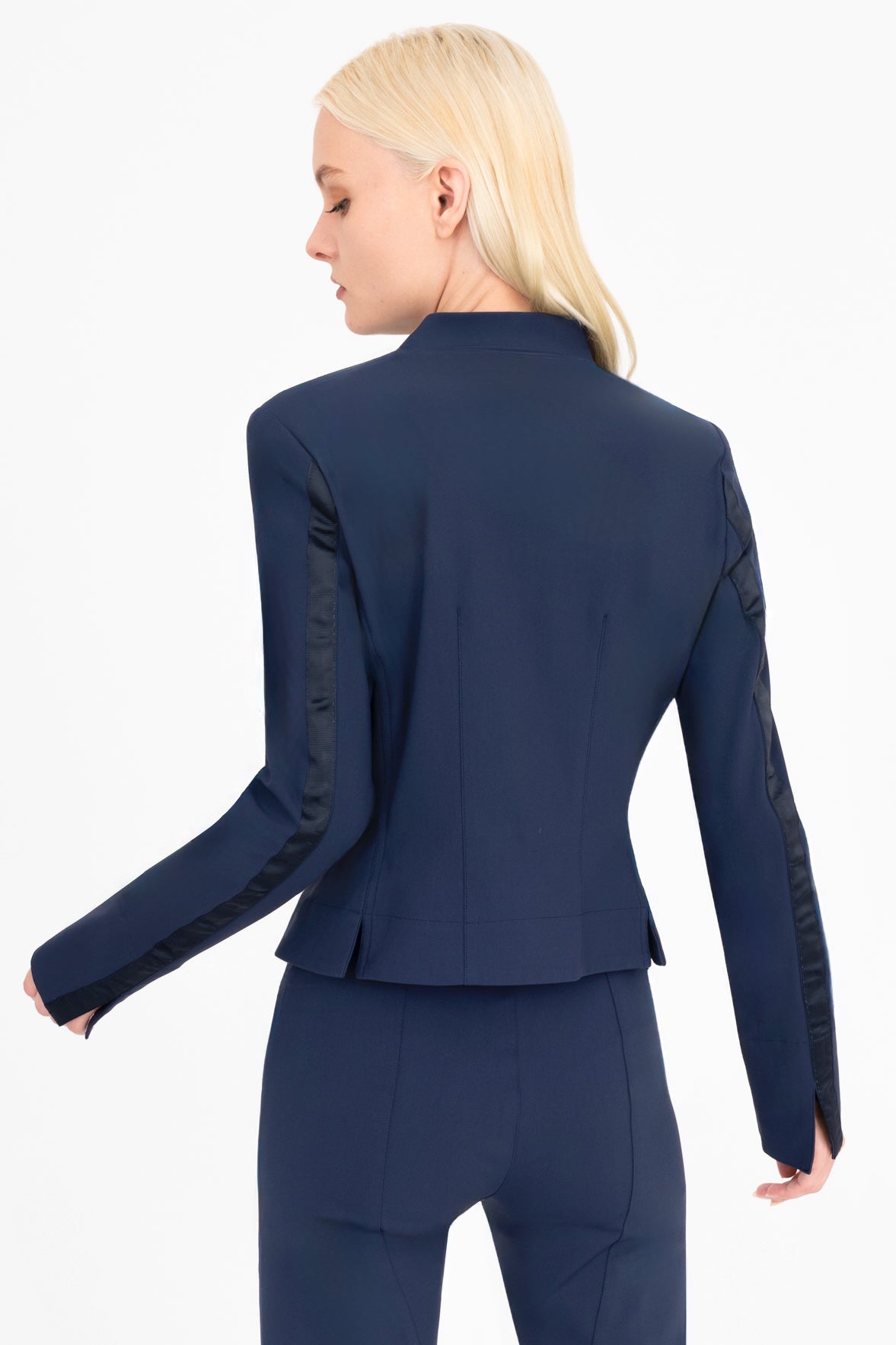 Woman wearing a navy moto jacket and pants on a white background