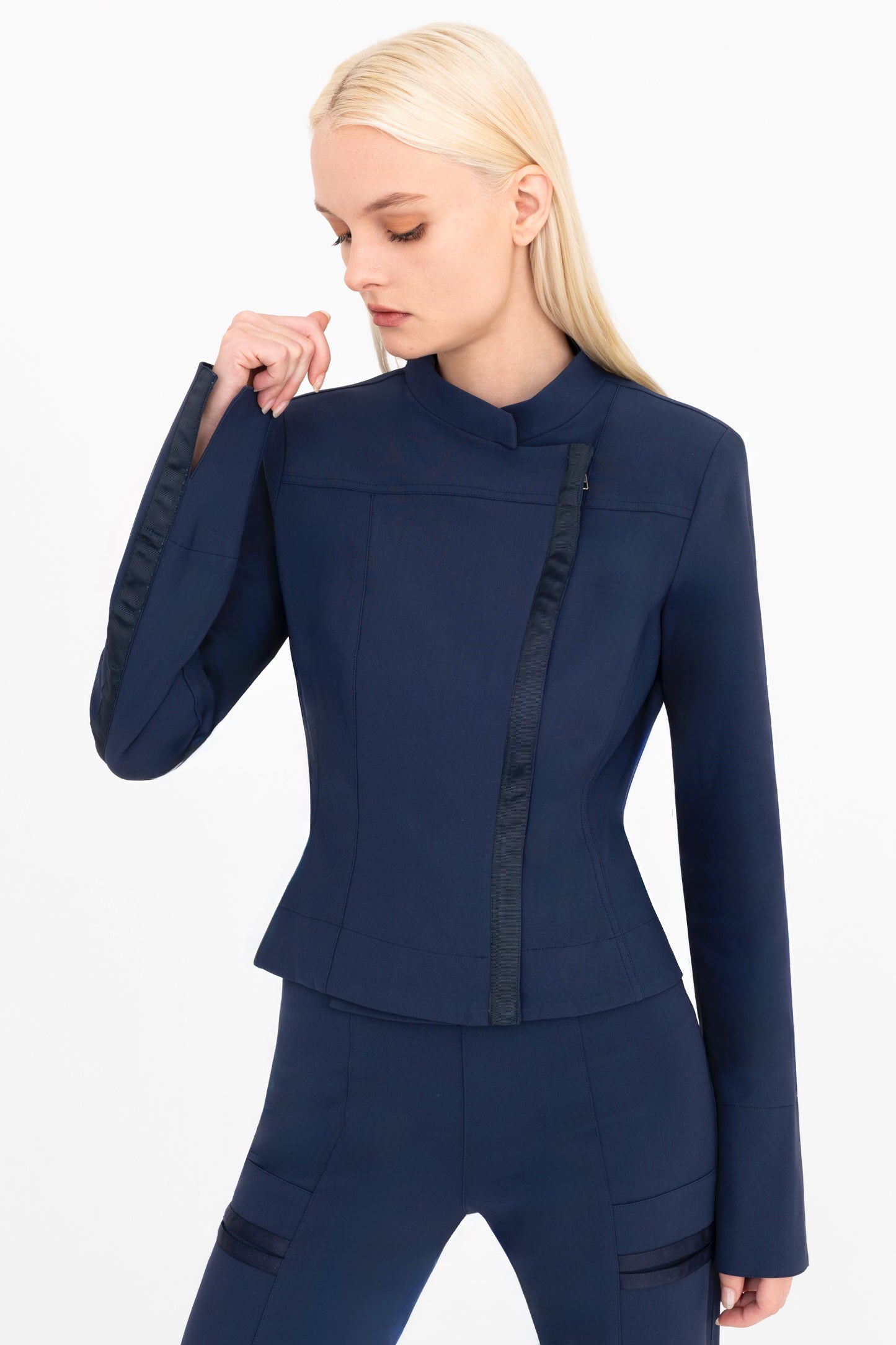 Woman wearing a navy moto jacket and pants on a white background