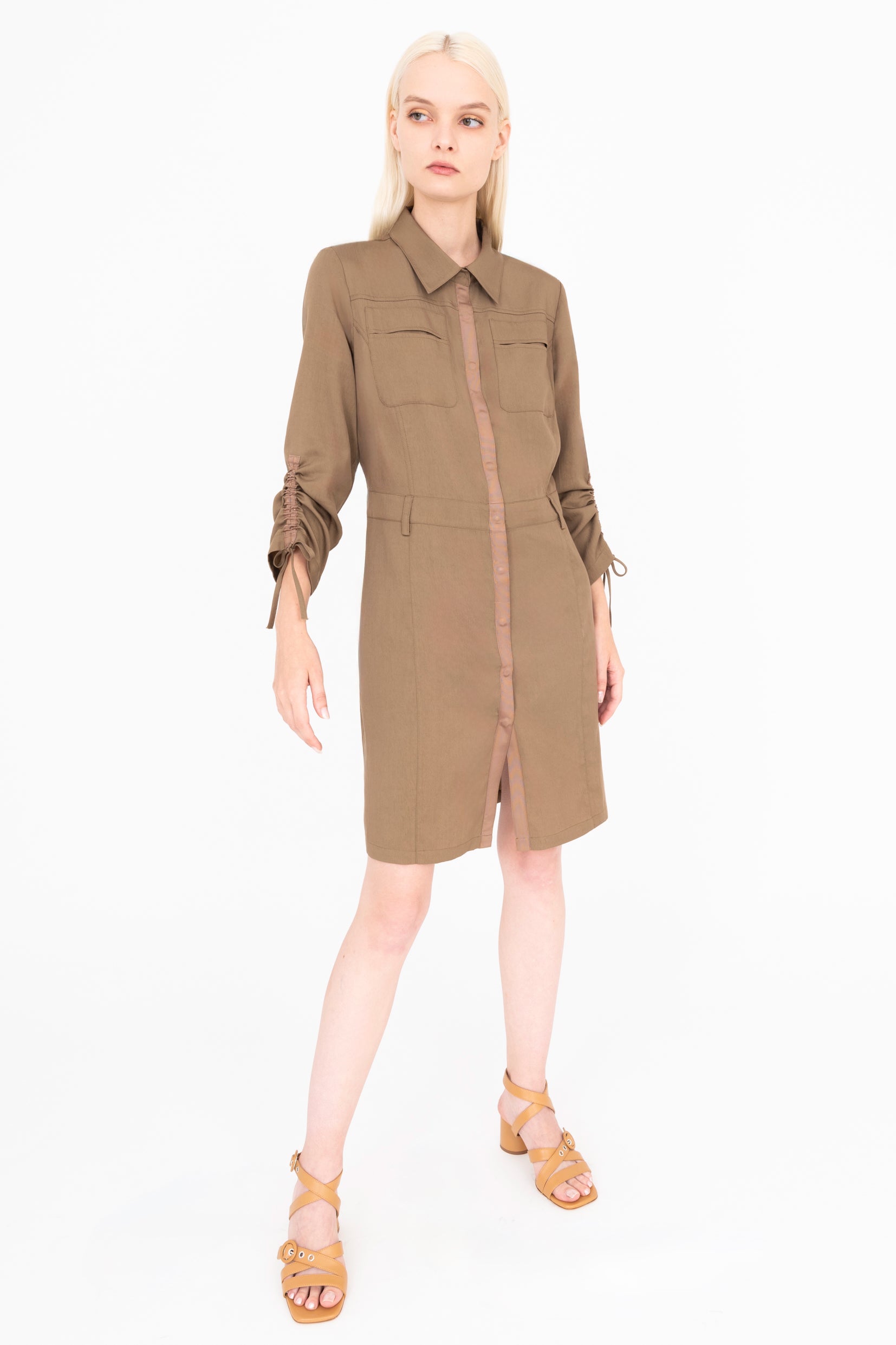 Front view of woman wearing a brown dress on a white background