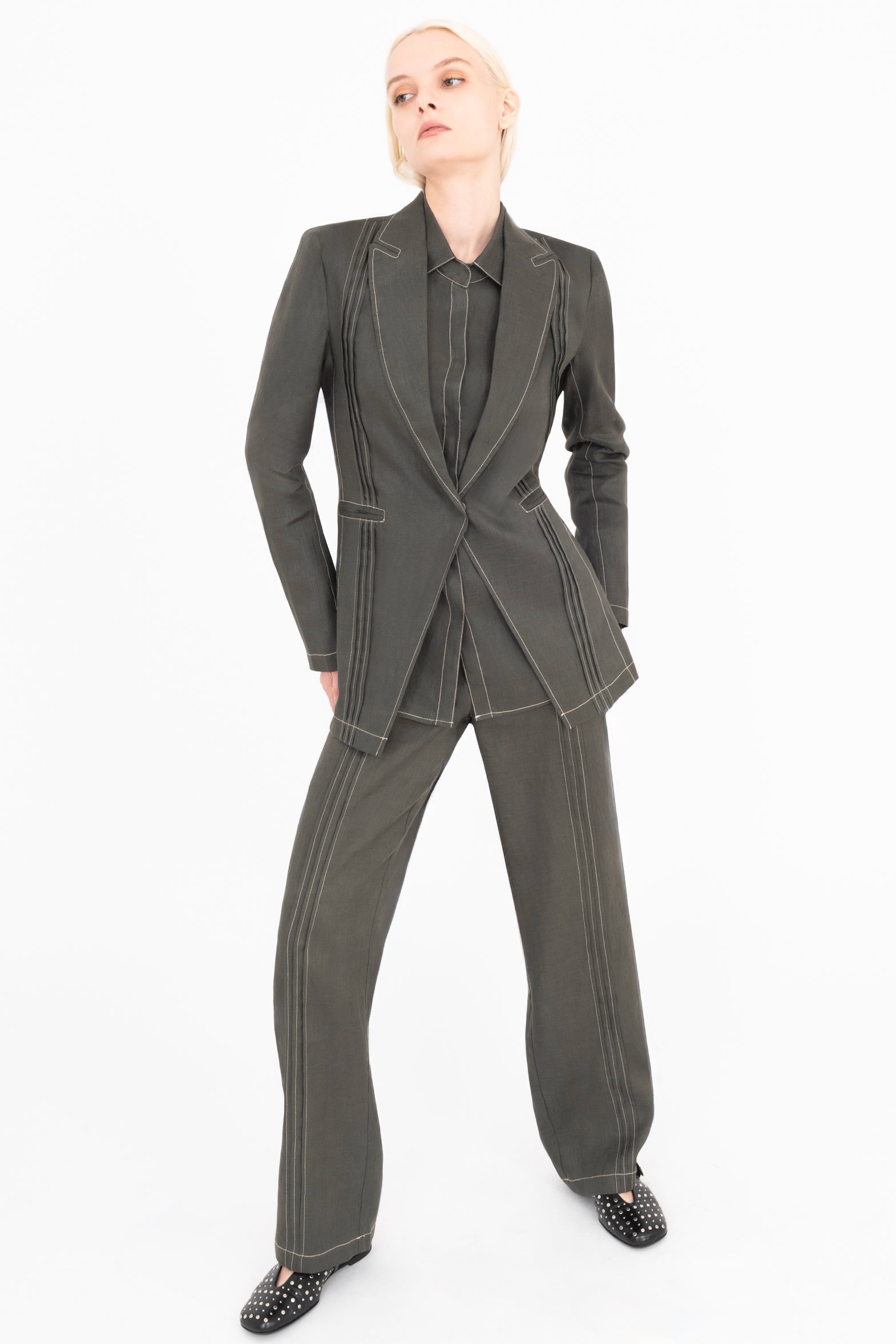 Person wearing a olive suit on a white background