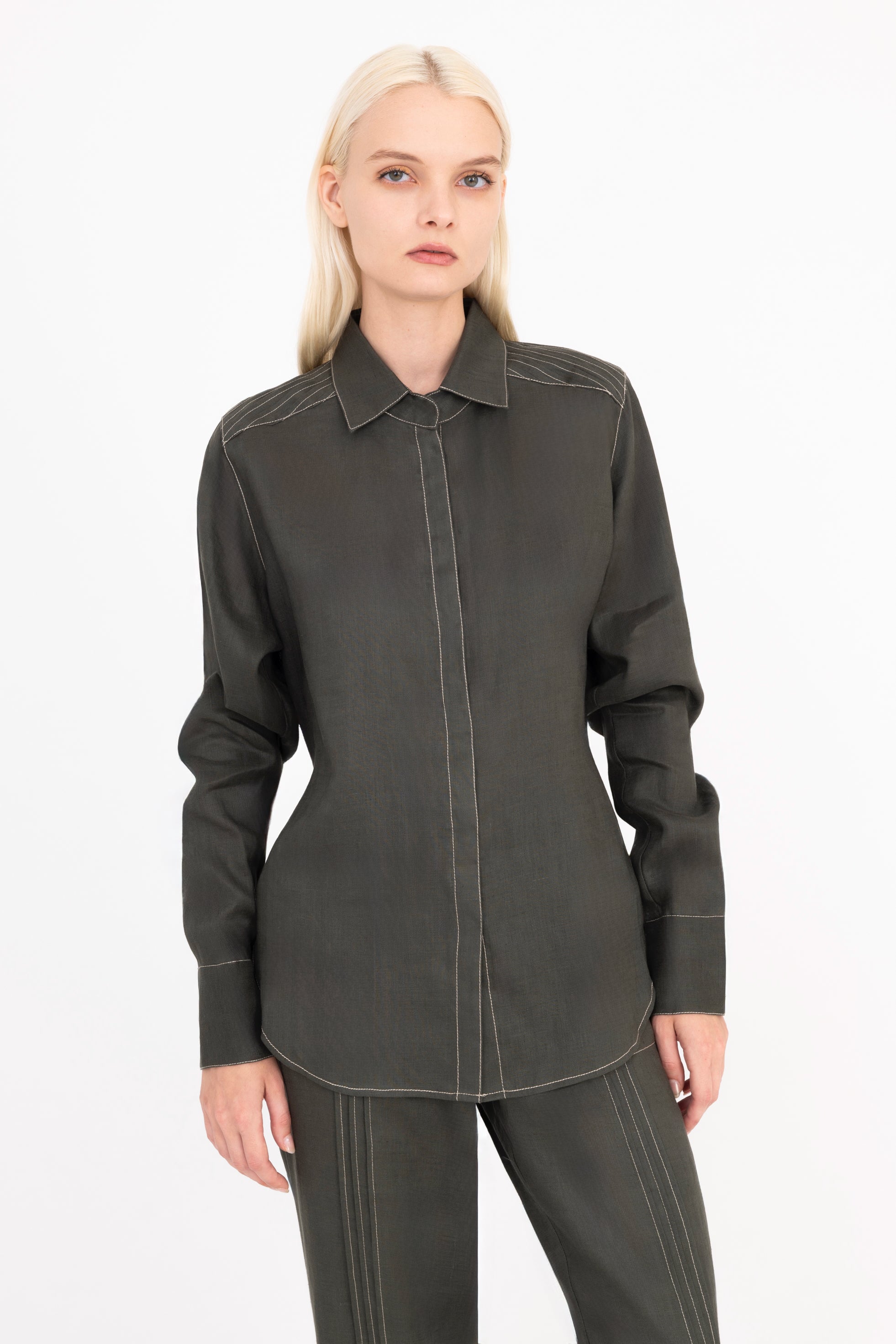 Woman wearing a green shirt and pants on a white background