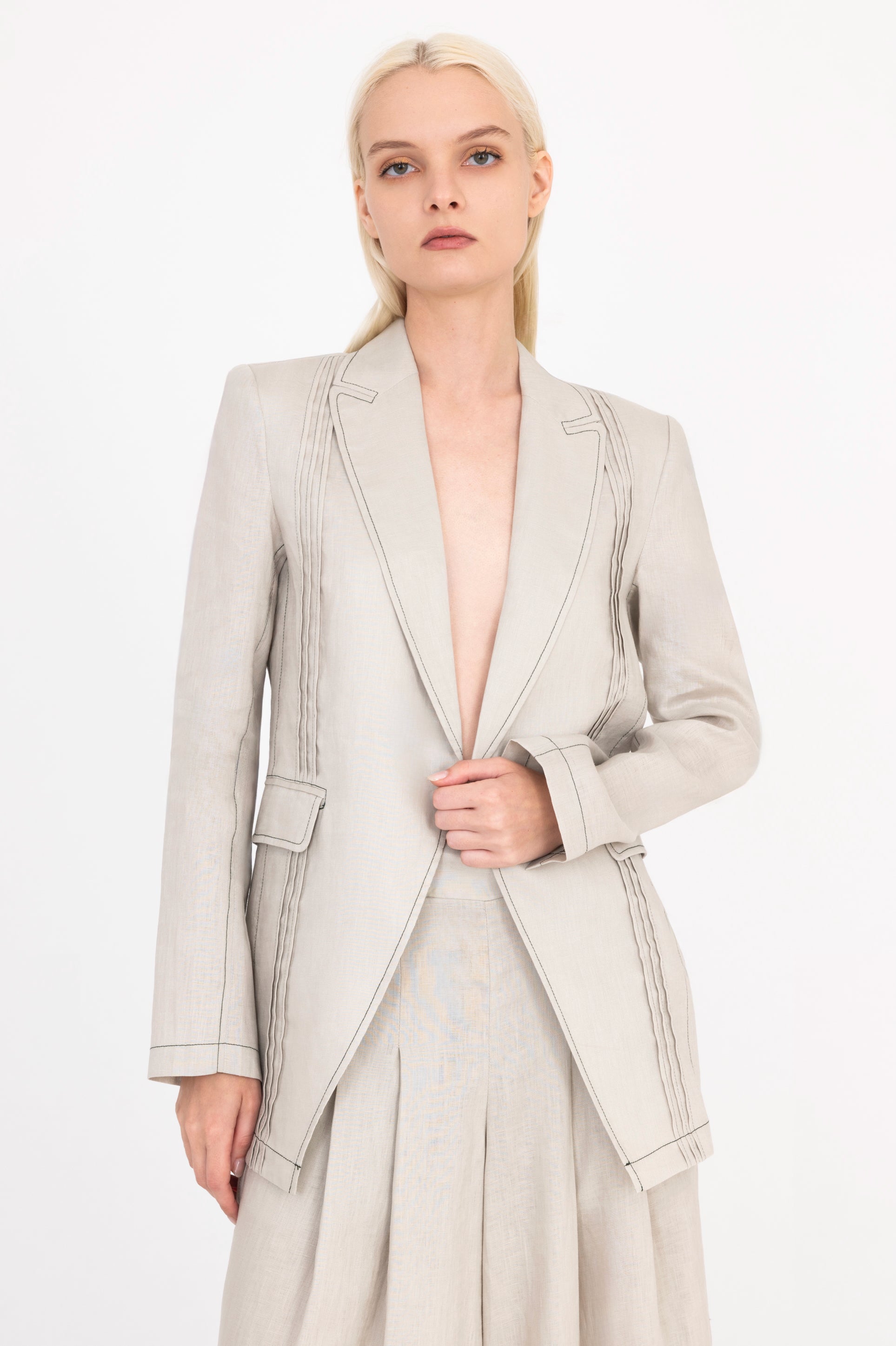 Woman wearing a light beige suit on a white background