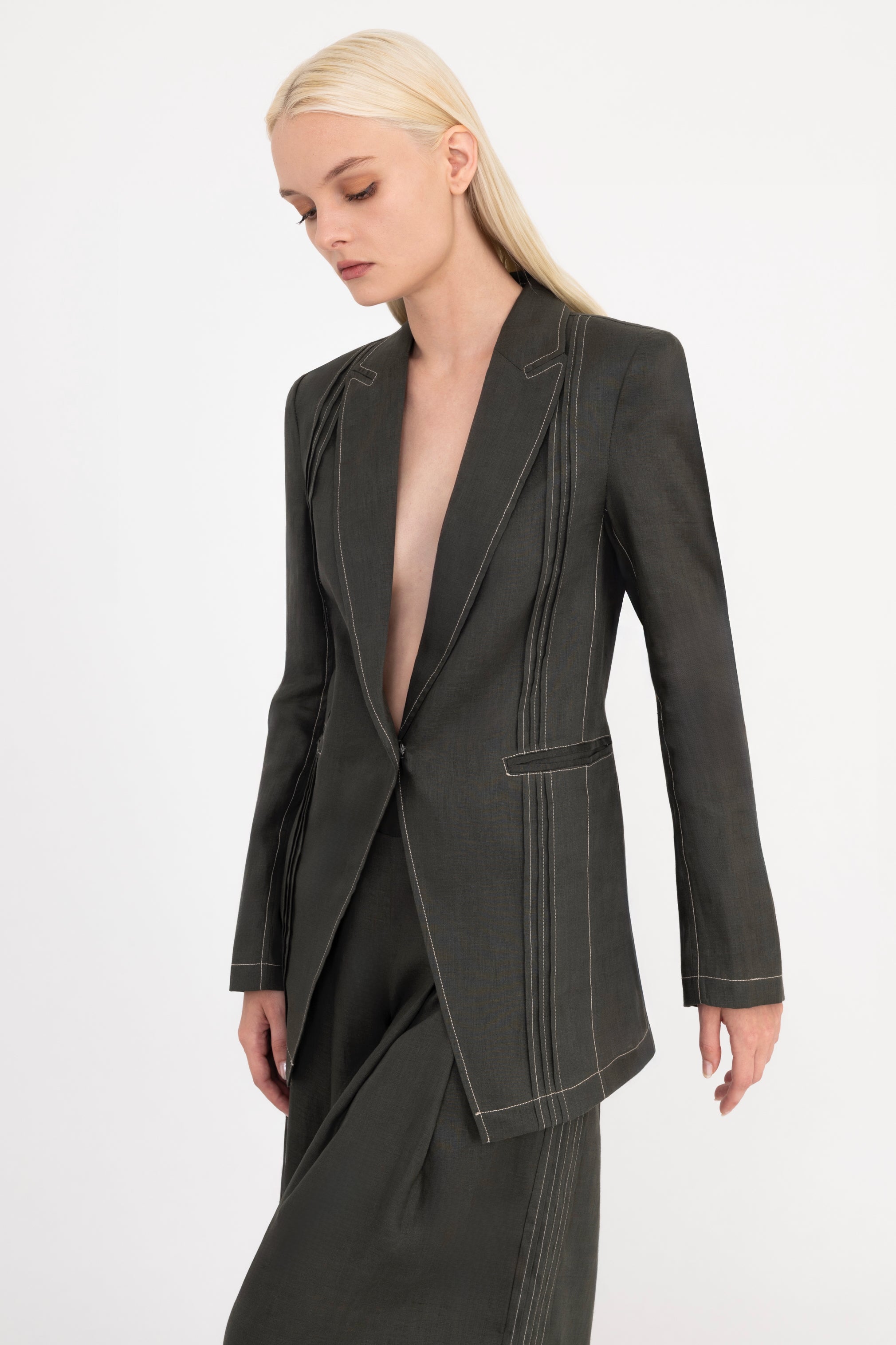 Woman wearing a olive suit on a white background