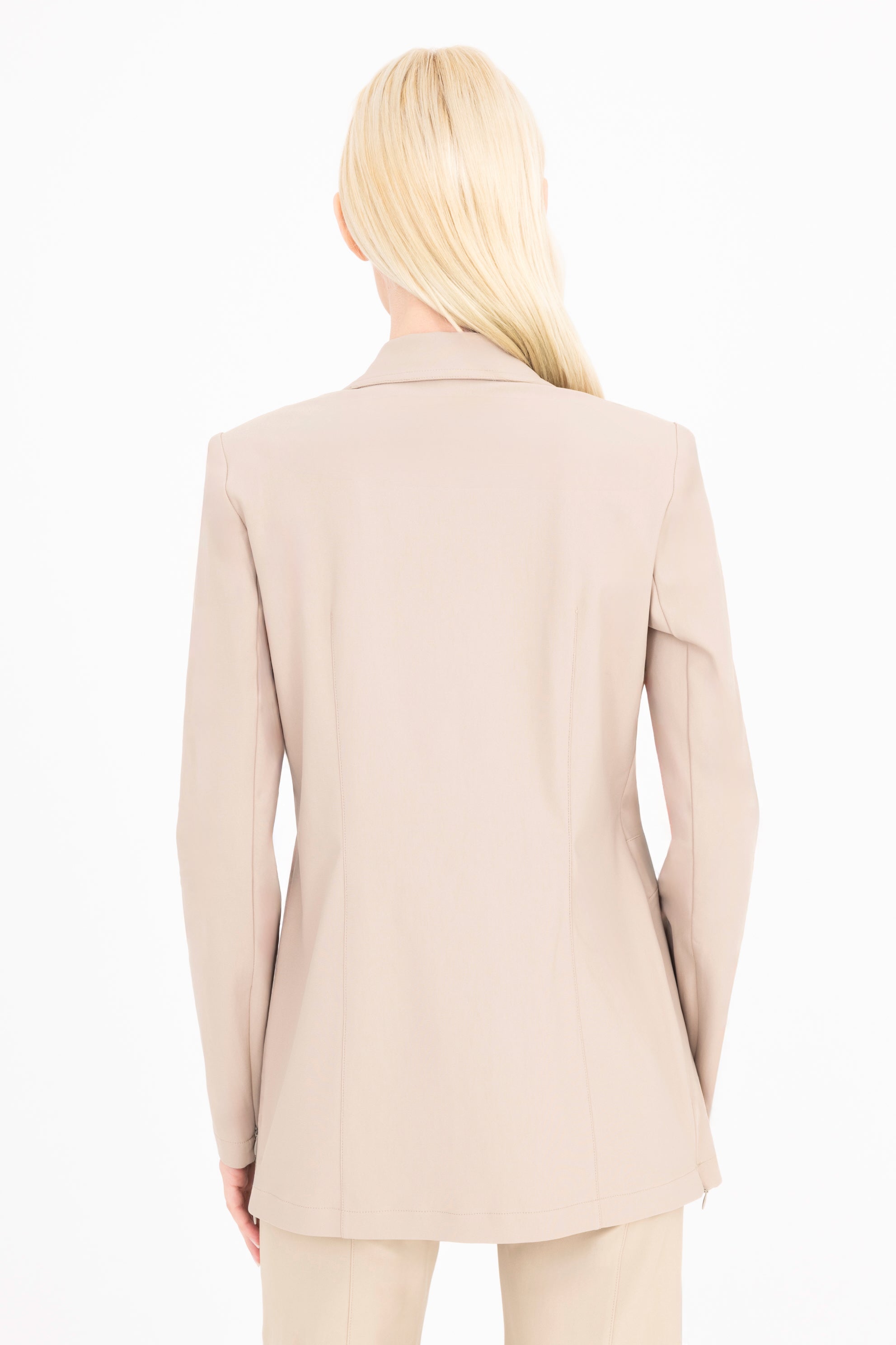 Person wearing a beige suit on a white background