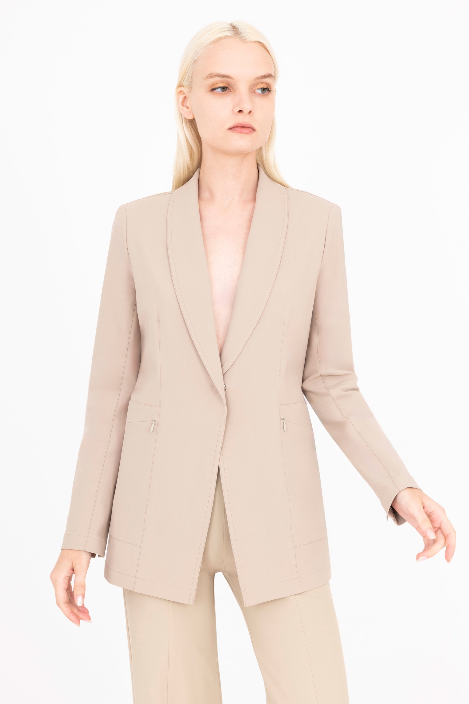 Woman wearing a beige suit on a white background