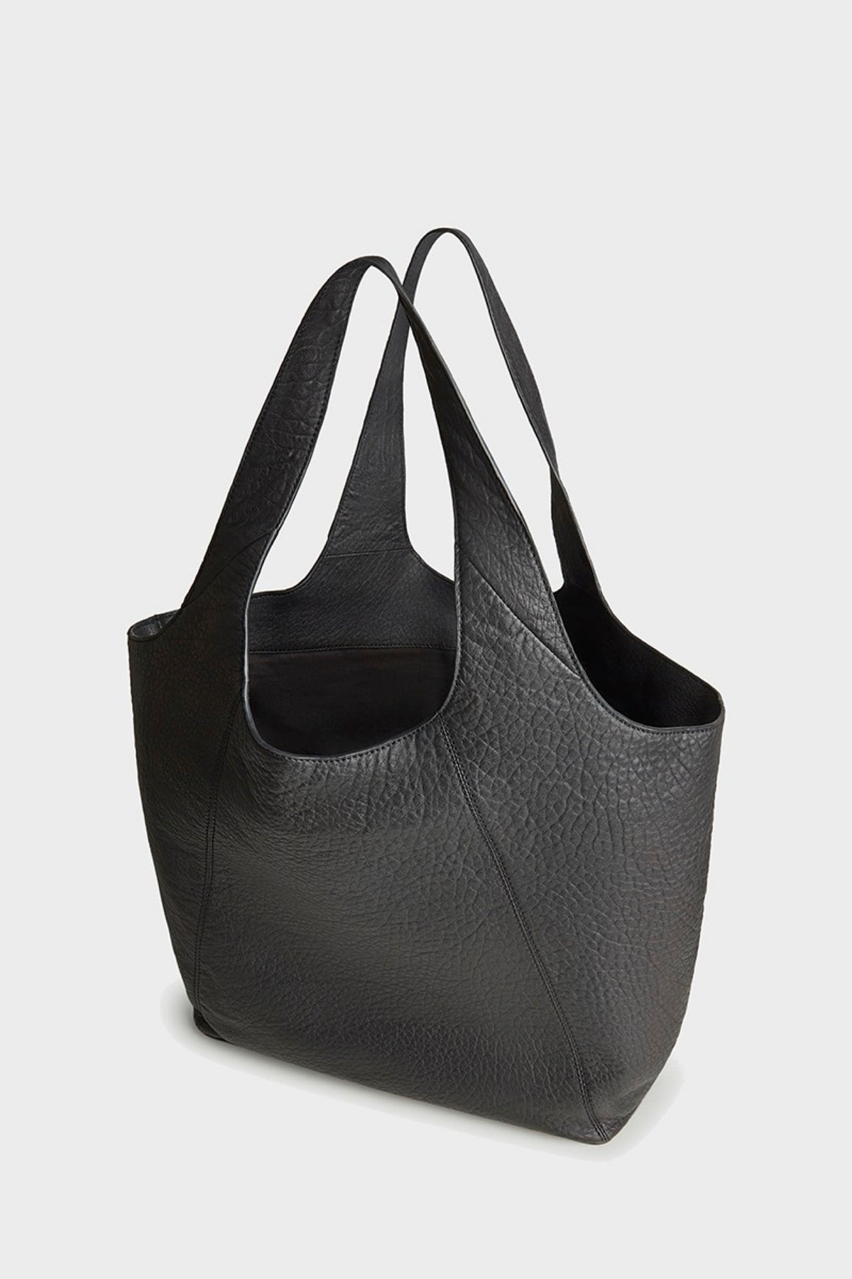 A black pebbled leather slouchy tote bag with double shoulder straps, shown from a three-quarters angle on a light gray background.