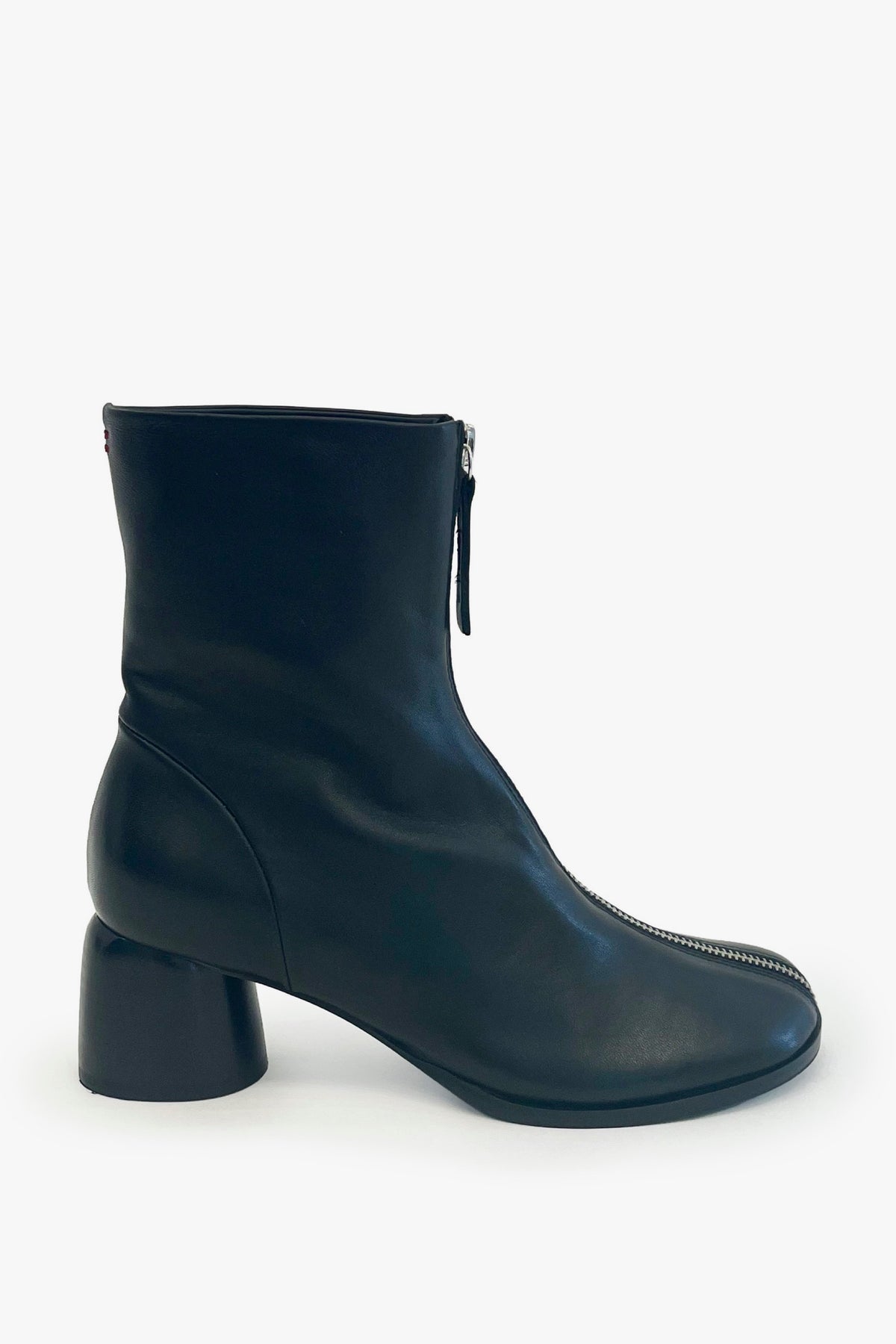 A single black leather ankle boot with a low block heel, a front zipper, and a zippered toe detail, shown against a plain white background.