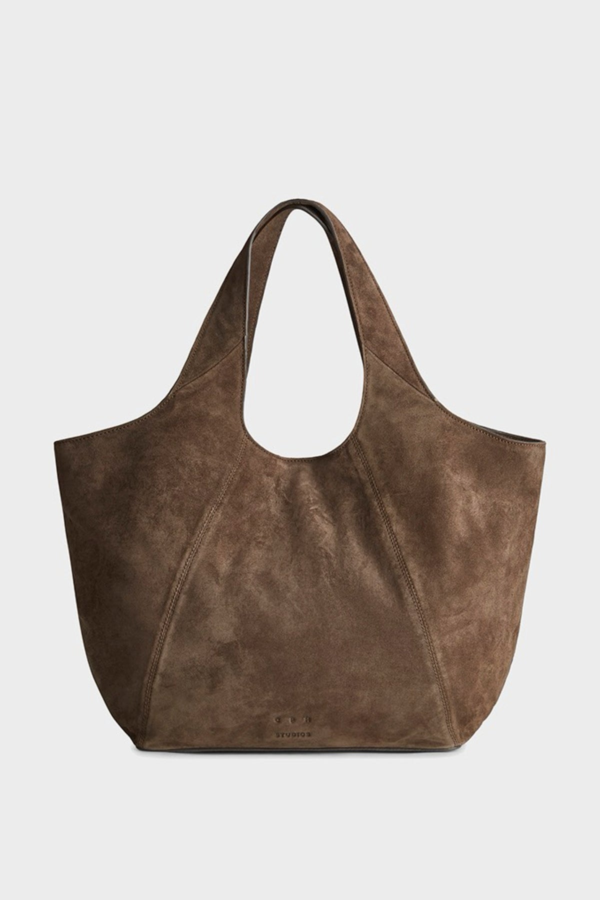 A brown suede tote bag with a circular cutout at the top and double shoulder straps, shown against a light gray background.