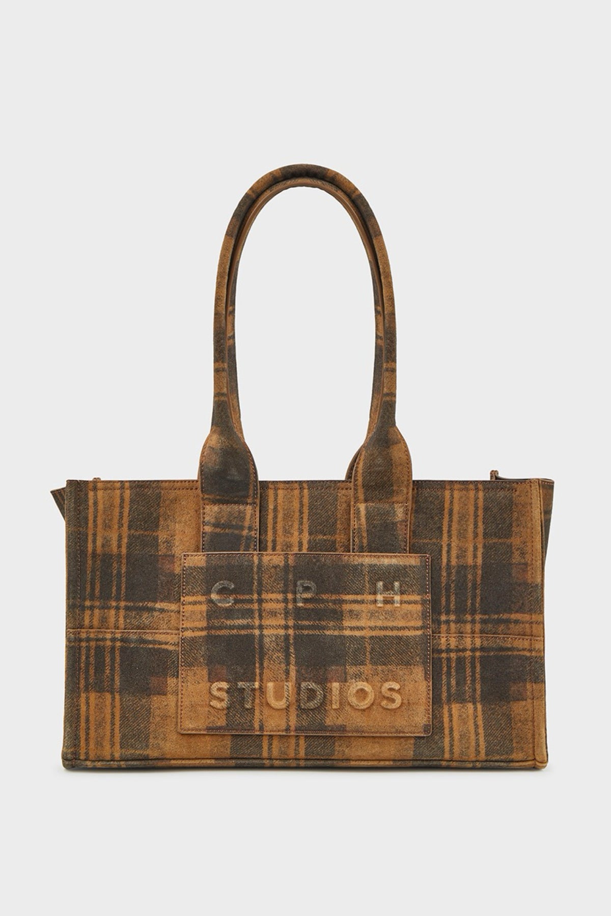 A brown and tan plaid suede tote bag with double top handles, featuring a front patch pocket with the text 'G R H STUDIOS' in gold lettering, set against a plain light gray background.
