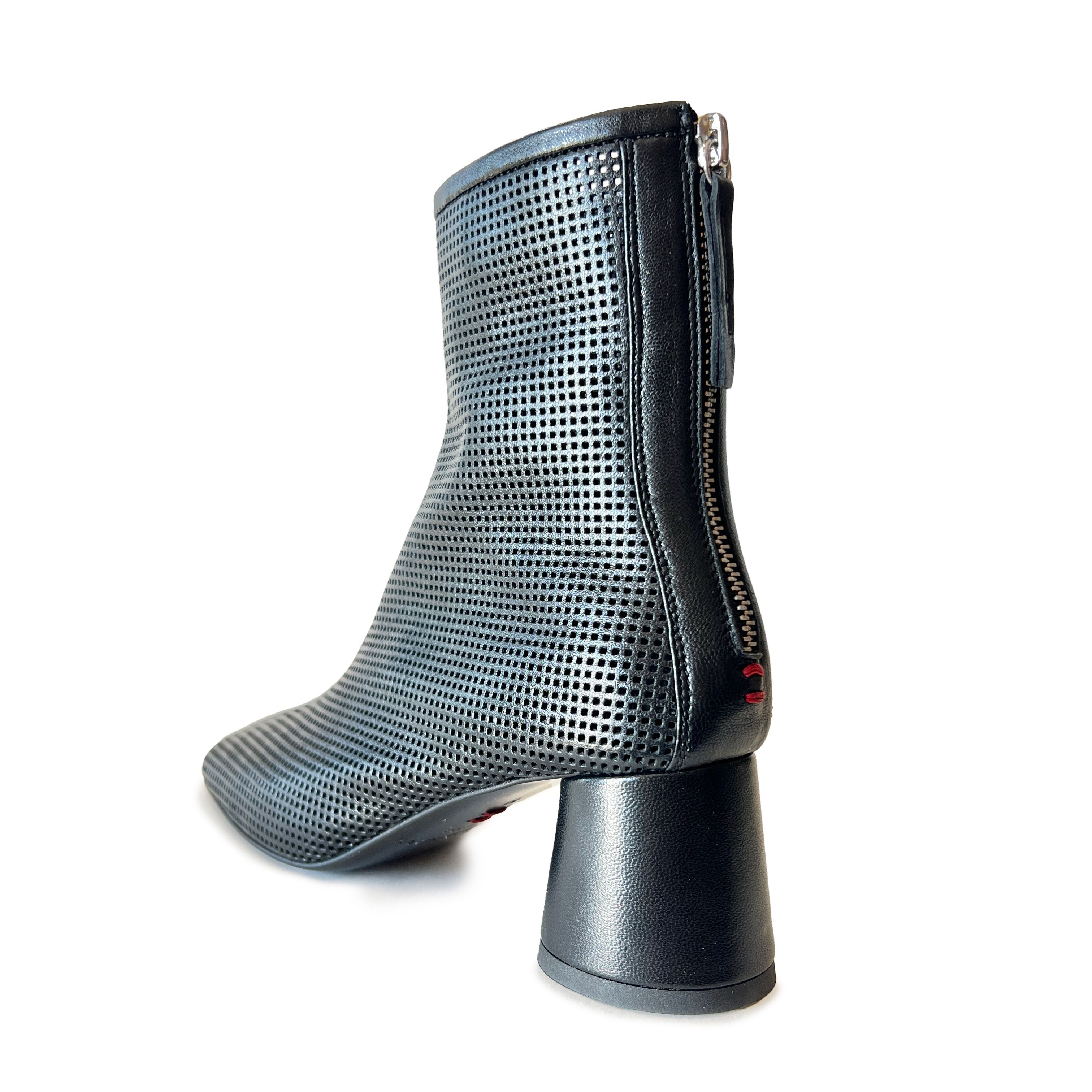 Black round toe perforated ankle boot on a white background