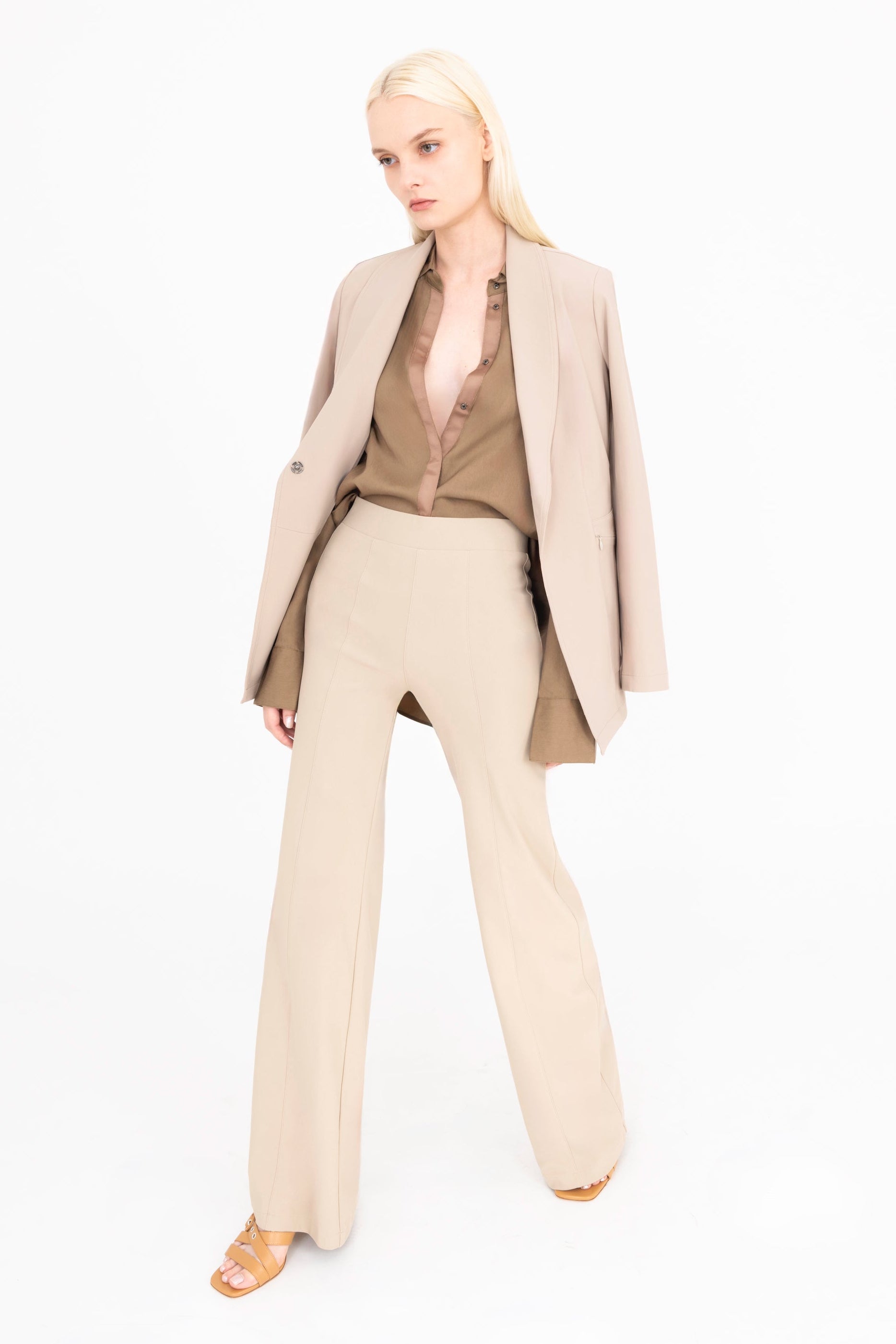 Woman wearing a beige suit on a white background