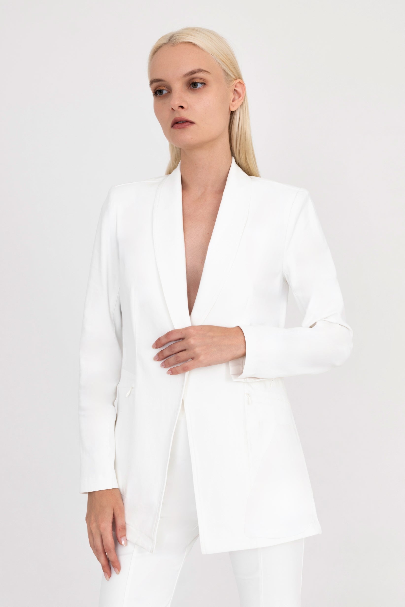 Woman wearing white blazer on a white background
