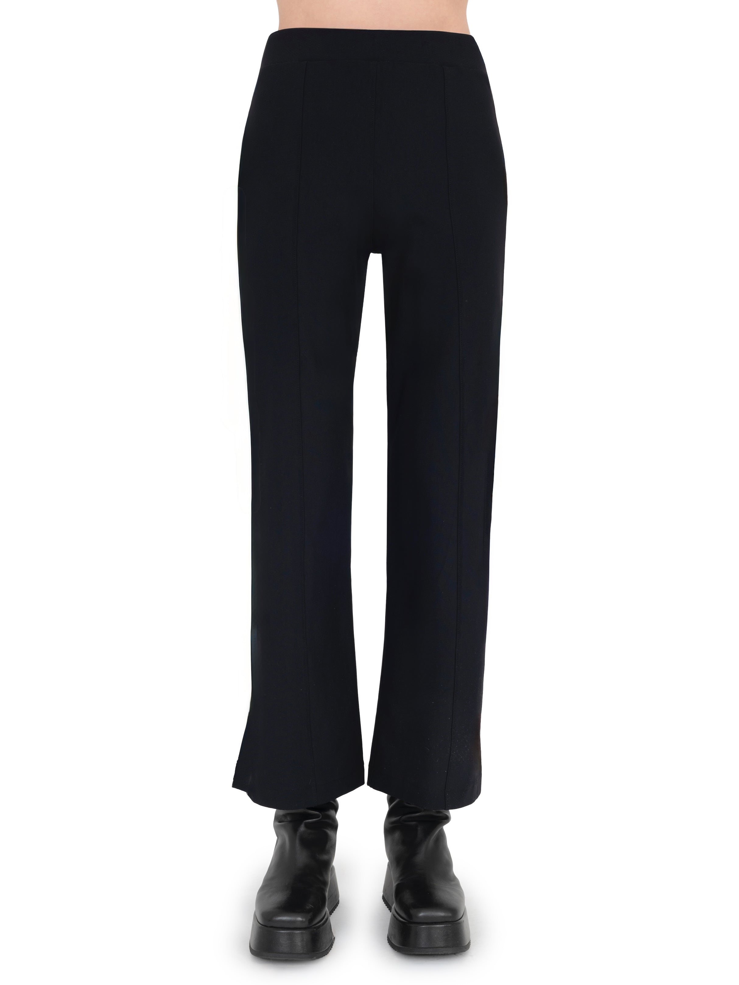 Black pants worn by a person on a white background