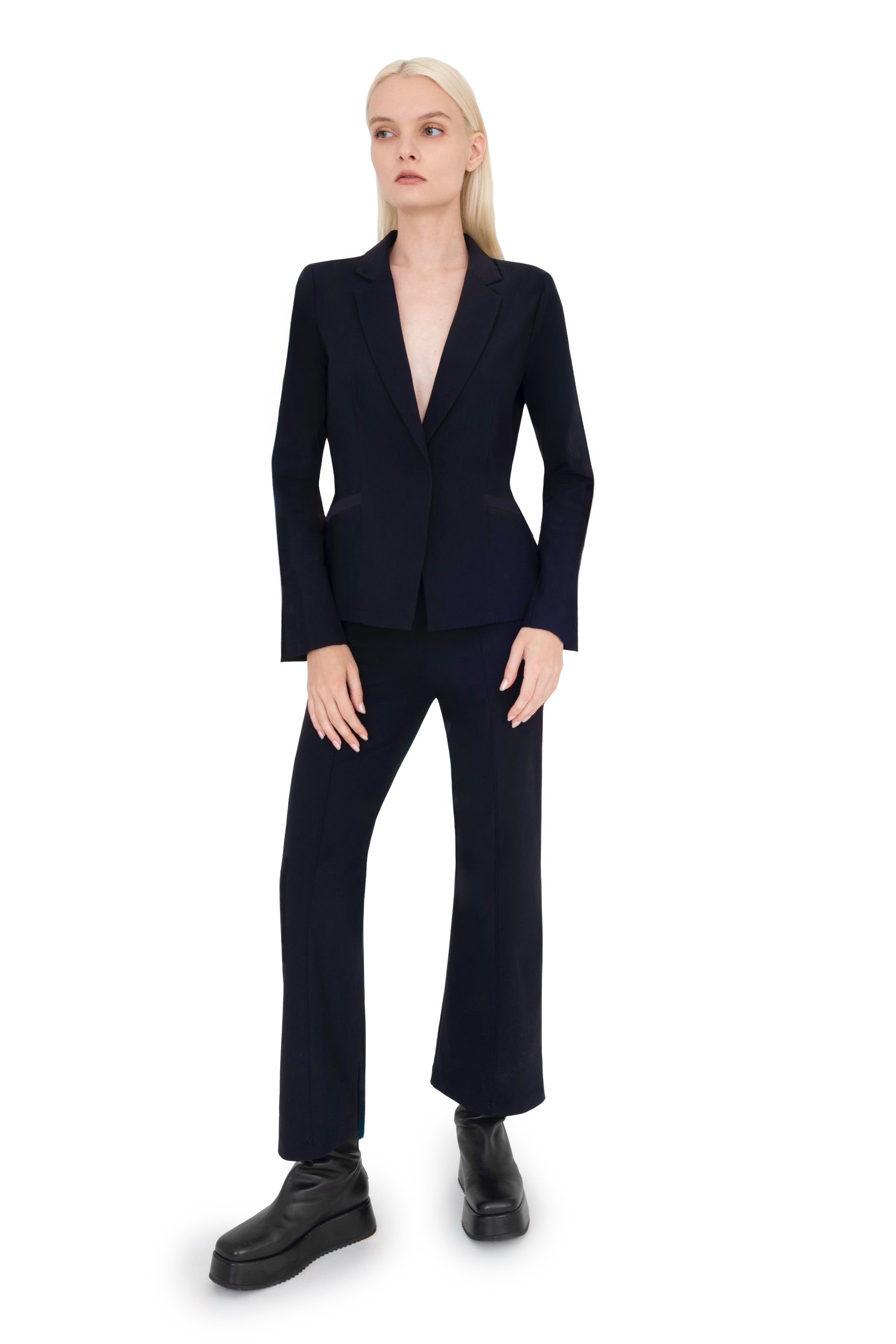 Woman wearing black suit against a white background