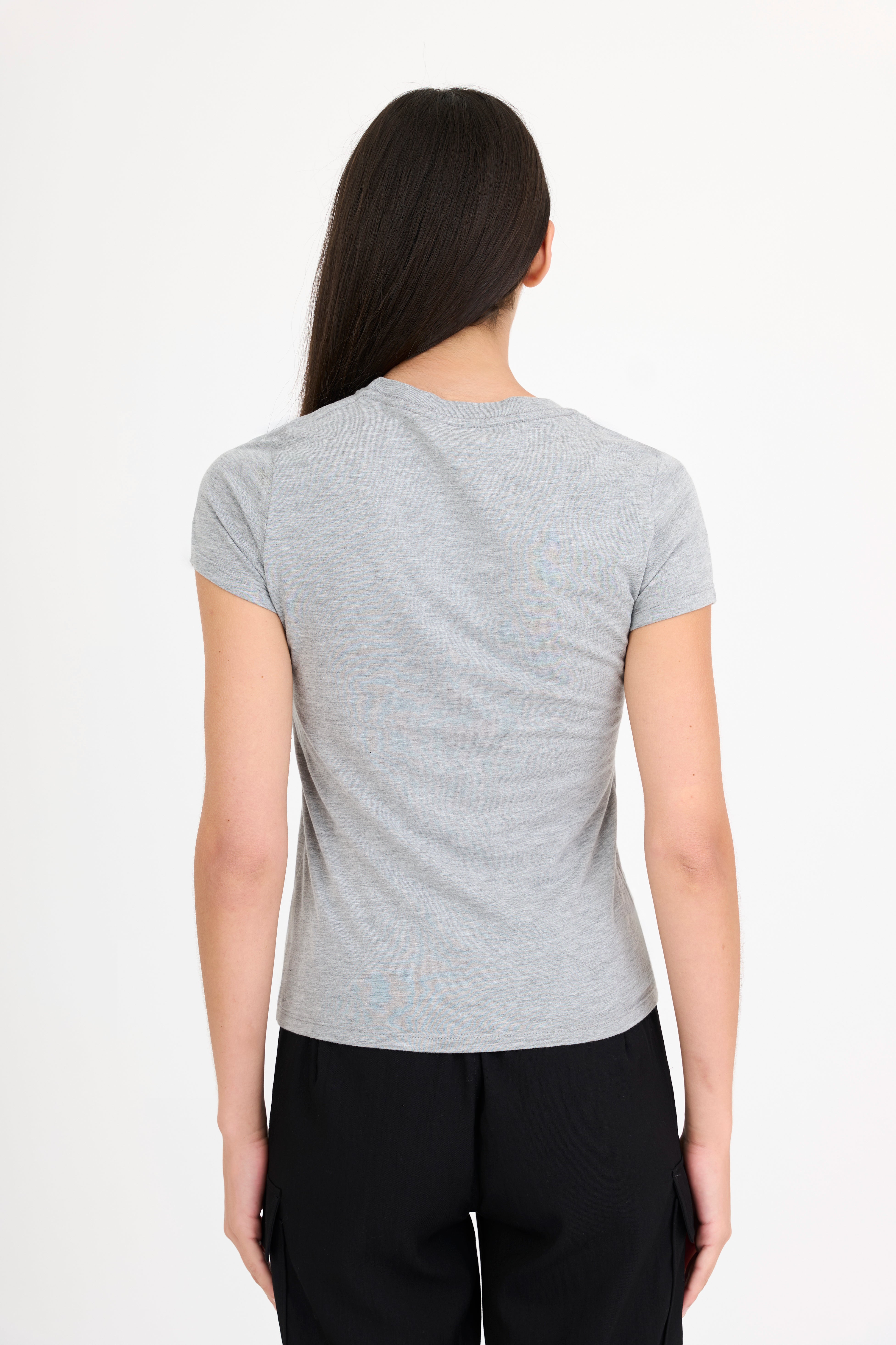Woman wearing a gray t-shirt and black pants on a white background