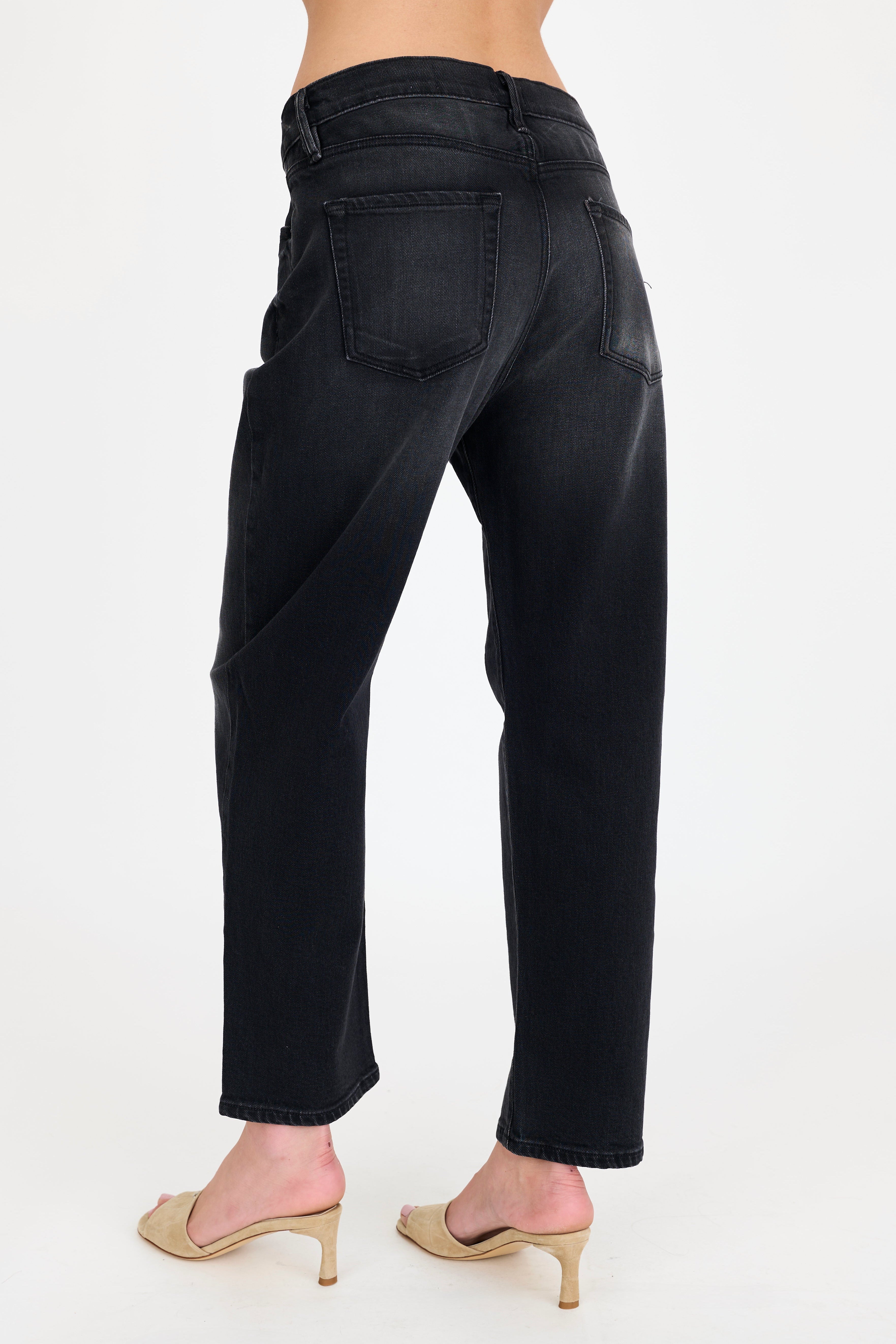 Black jeans worn by a person on a white background