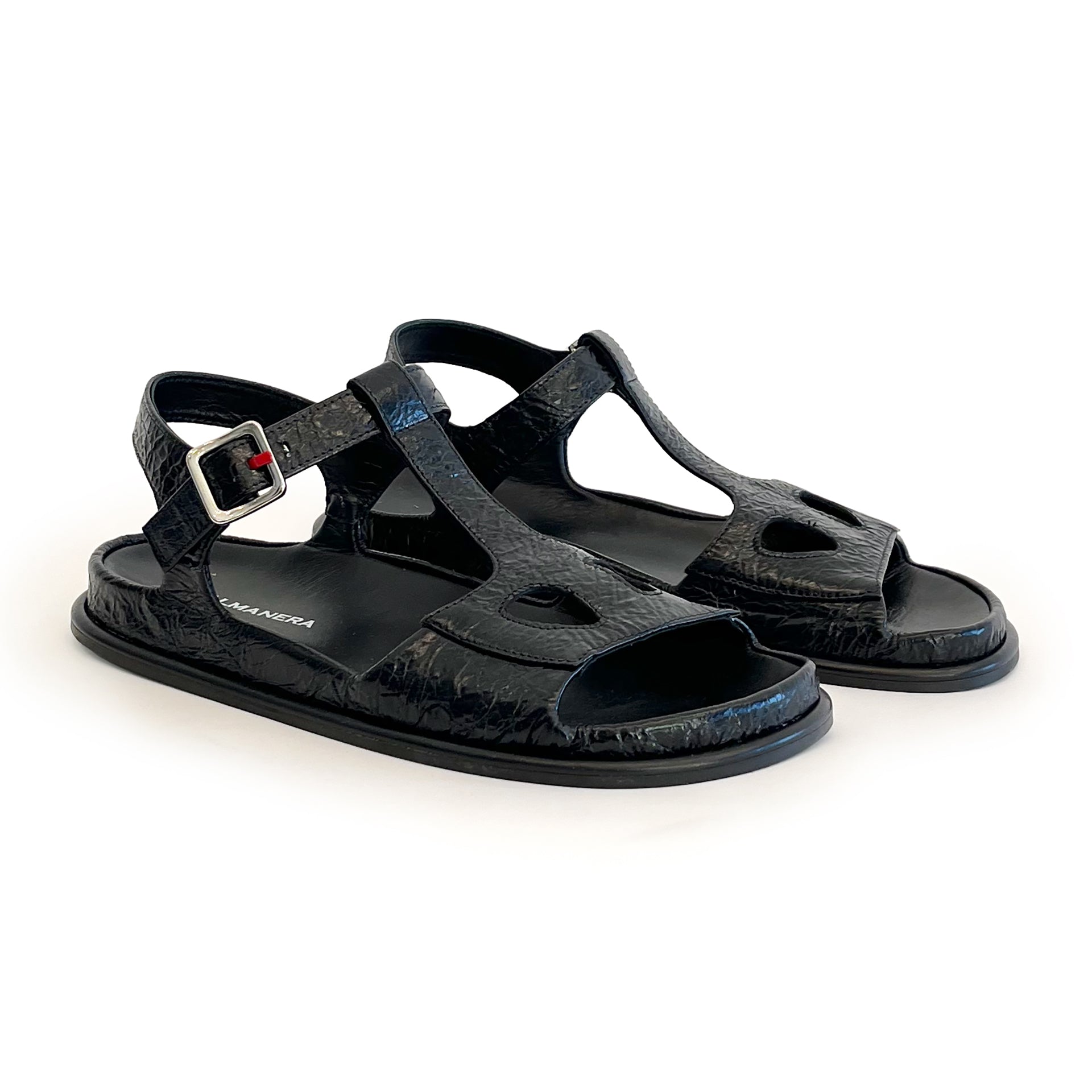 Black ankle strap flat sandals on a white background