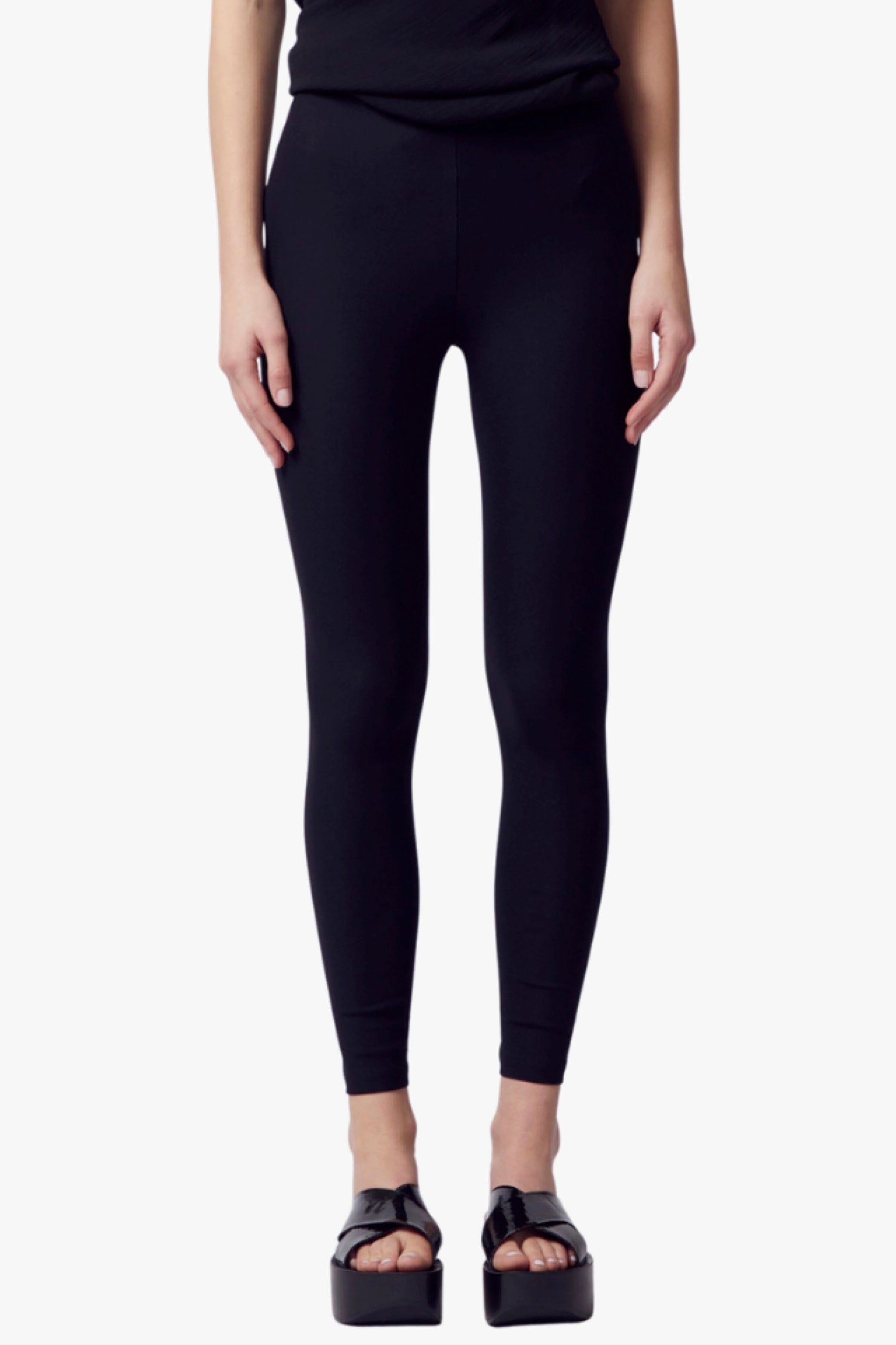 Person wearing black leggings on a white background